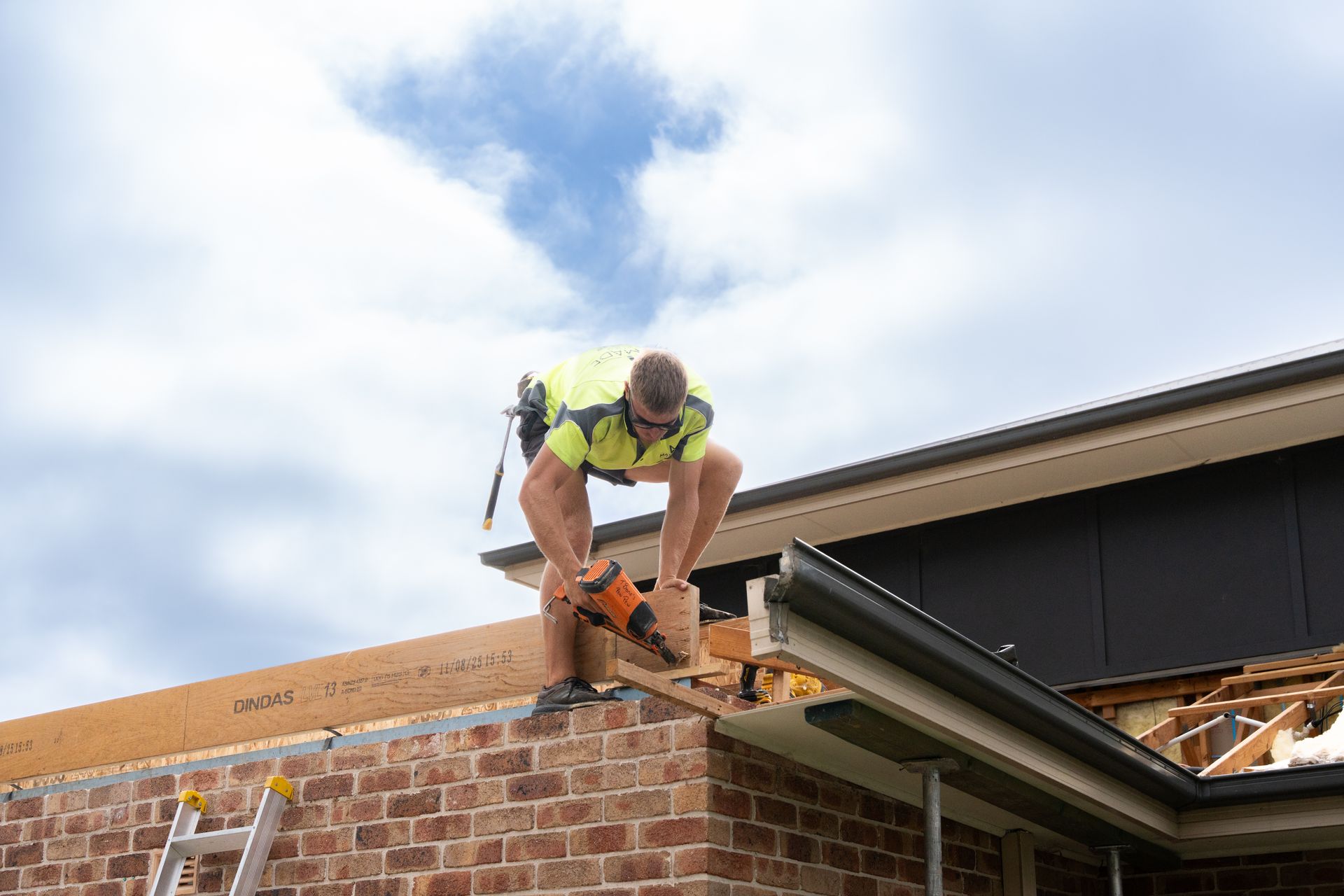 Open Garage With a Car Seat and Household Items Inside Beside a Beige House — Matt Made Building in Camden, NSW