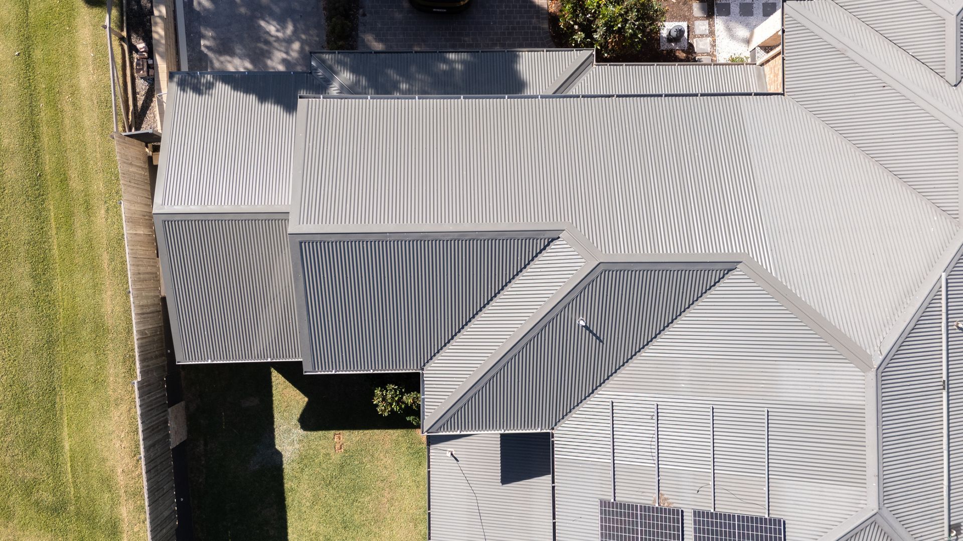 Aerial View of a Gray Metal Roof With Multiple Sections and a Patch of Green Lawn — Matt Made Building in Camden, NSW