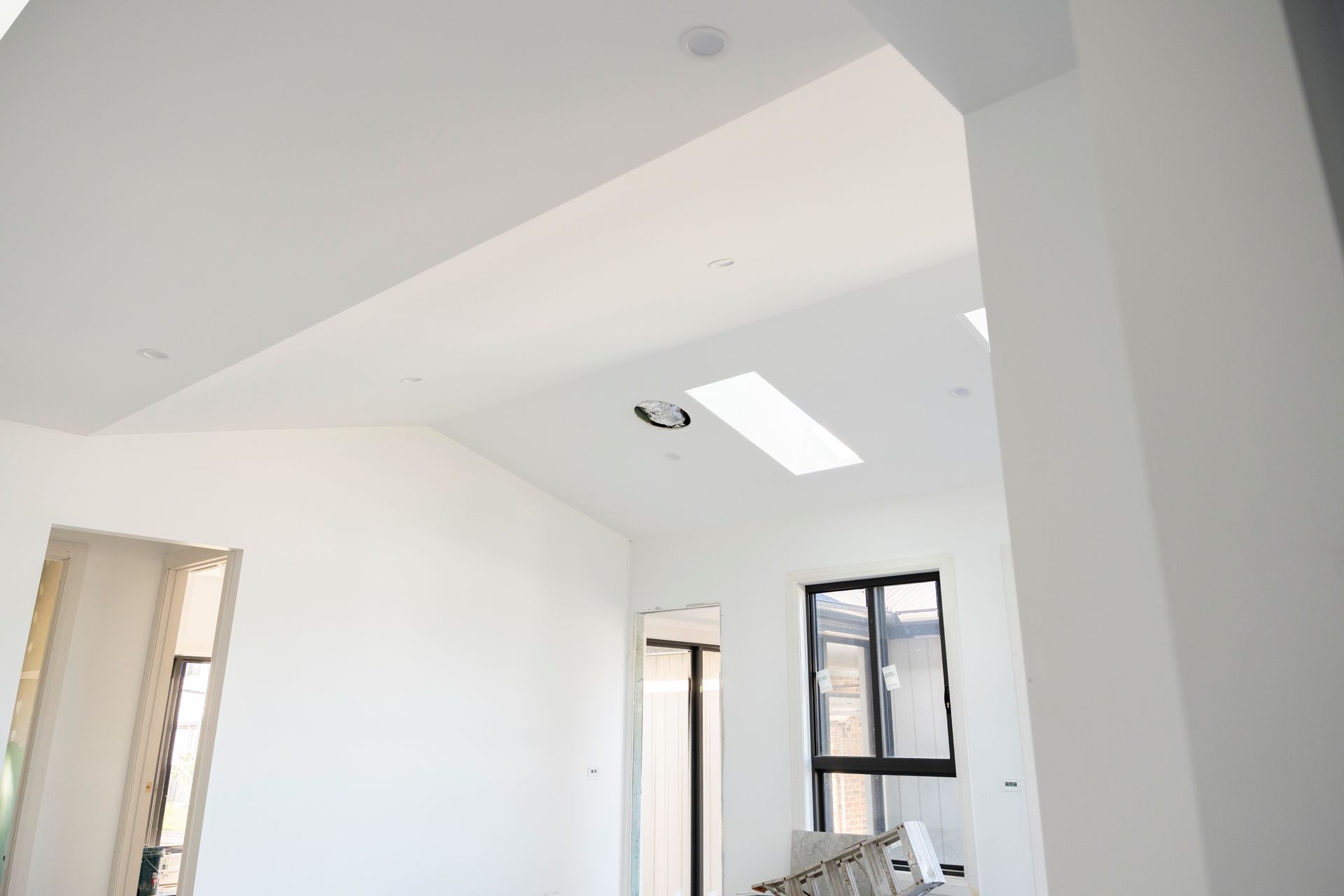 Bright White Room Under Construction With Skylight, Exposed Doorways, and Window — Matt Made Building in Camden, NSW