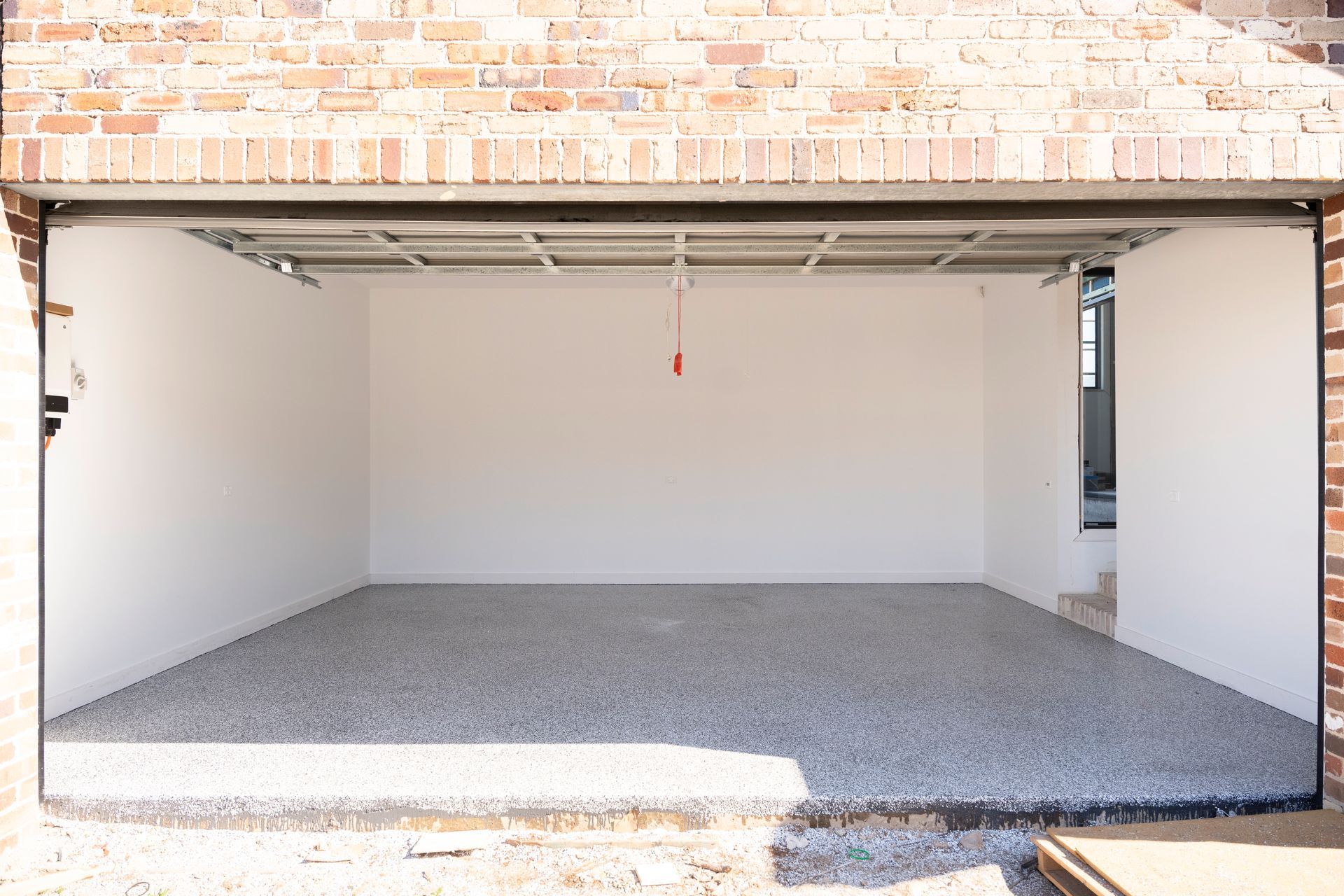 Empty Two-car Garage Interior With White Walls, Open Door, and Gravel Floor — Matt Made Building in Camden, NSW