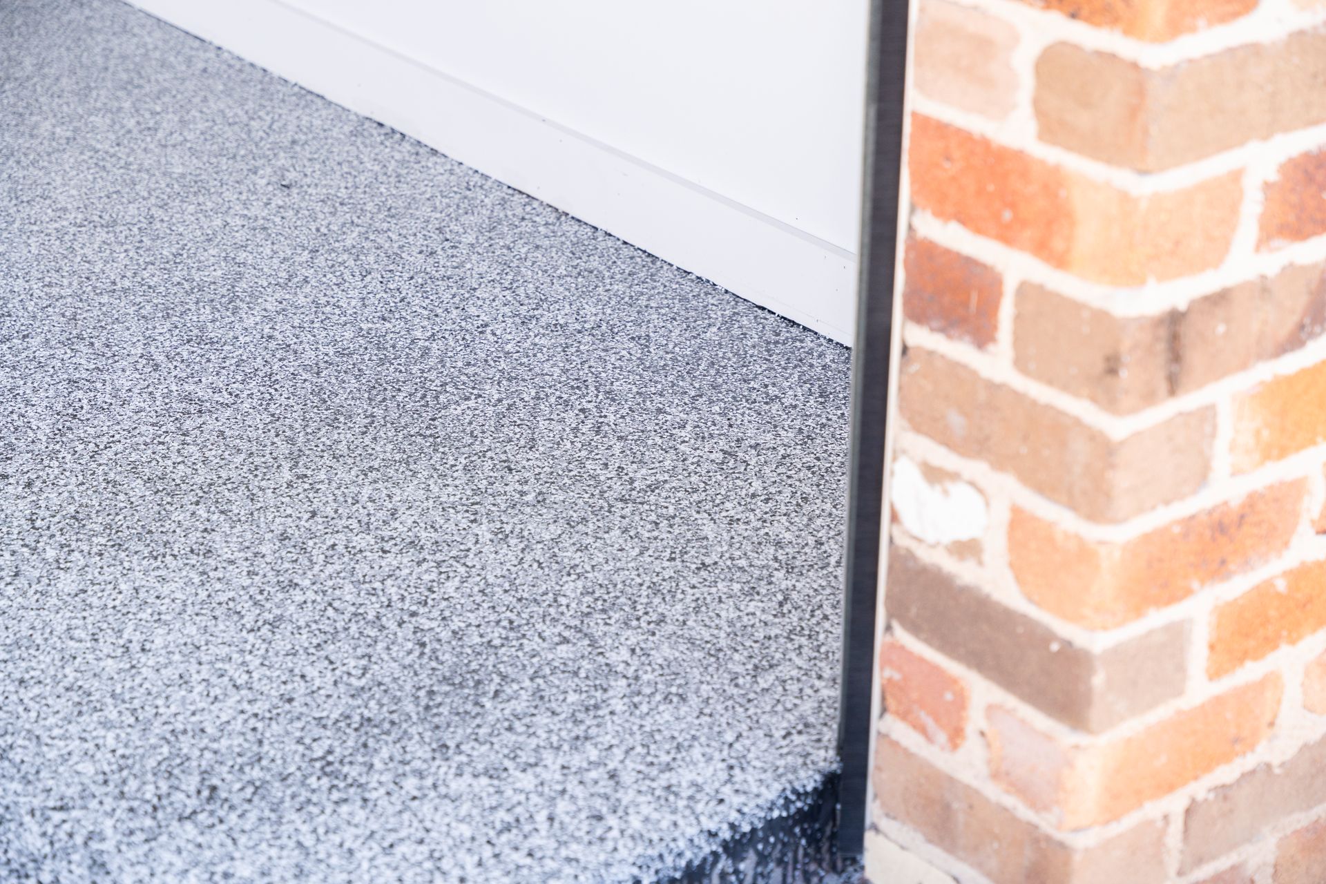 Speckled Gray Porch Floor Beside a White Wall and Brick Column — Matt Made Building in Camden, NSW