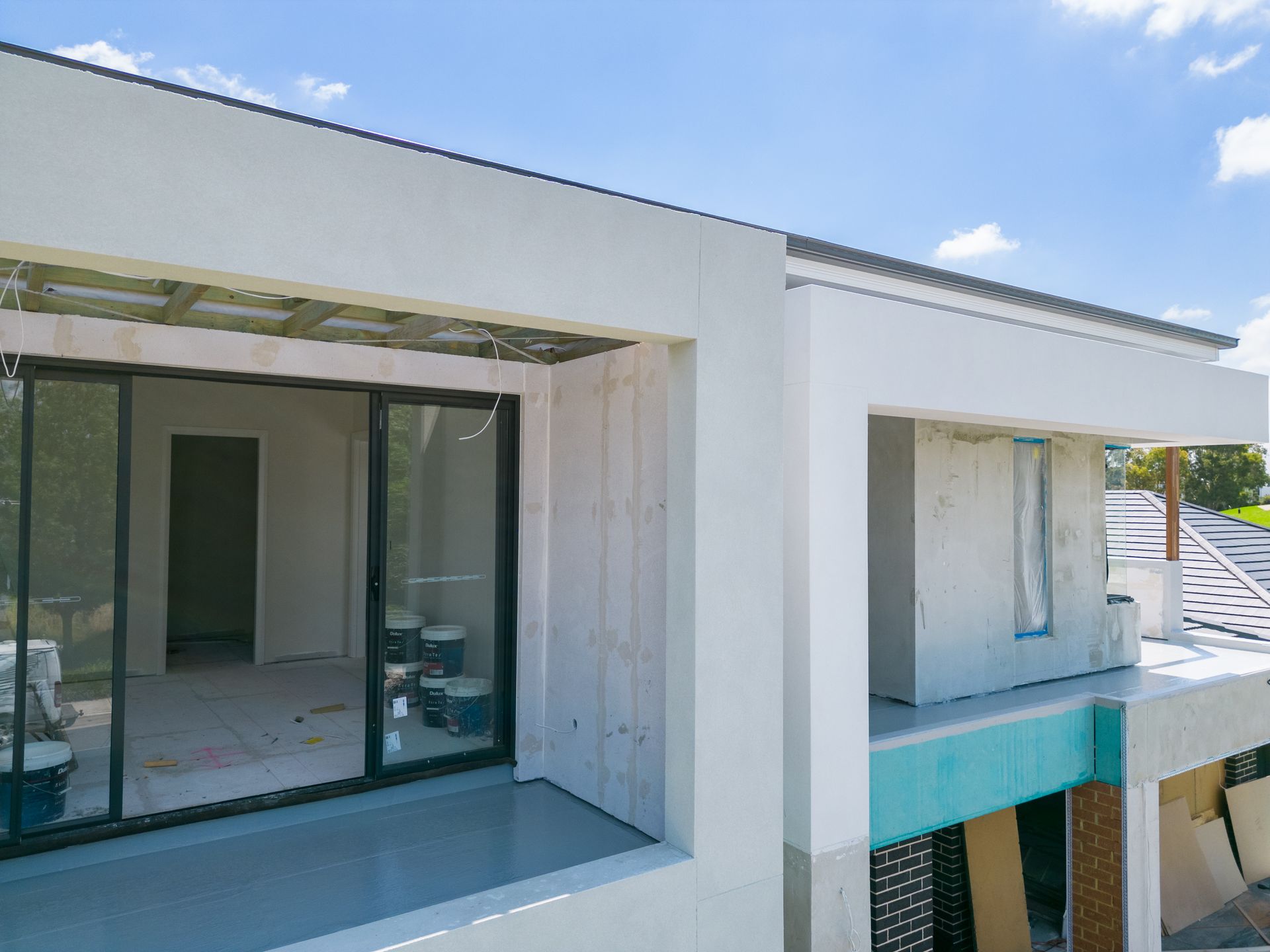 Modern White Apartment Balconies With Large Glass Doors and Blue Sky Above — Matt Made Building in Camden, NSW
