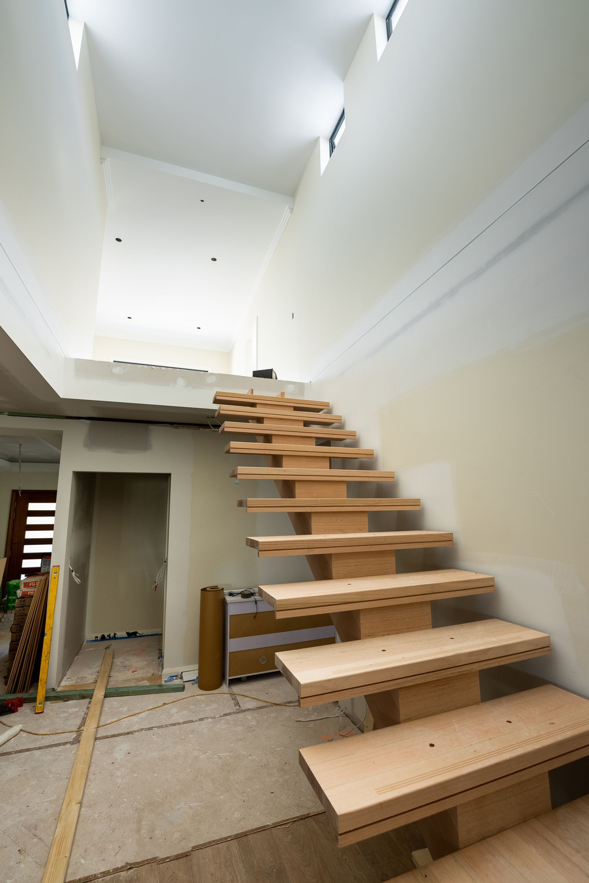 Modern Indoor Staircase With Wooden Treads in a Bright, Unfinished Hallway — Matt Made Building in Camden, NSW