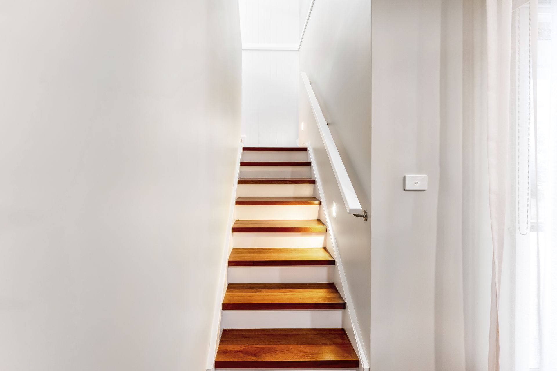 Narrow White Hallway With Wooden Staircase Leading Upward — Matt Made Building in Camden, NSW