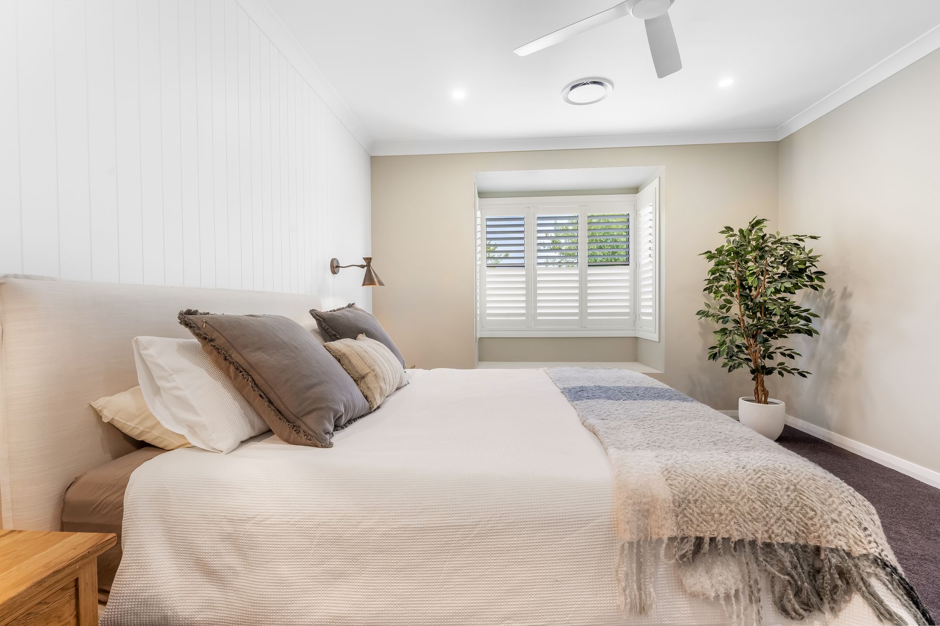 Bright Bedroom With a Neatly Made Bed and Potted Plant in a Minimalist Interior — Matt Made Building in Camden, NSW