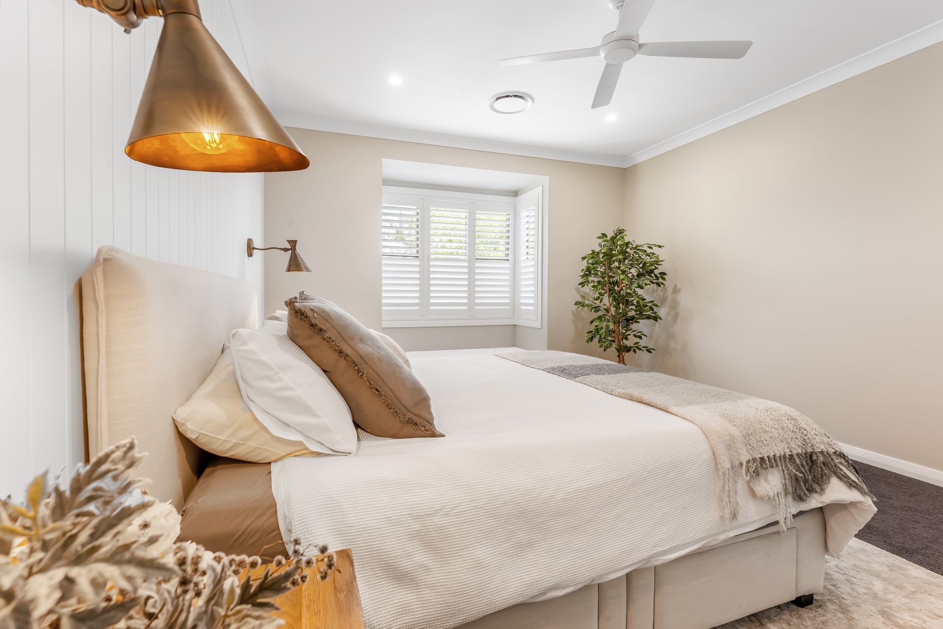 Bright Bedroom With a Neatly Made Bed and a Potted Plant — Matt Made Building in Camden, NSW