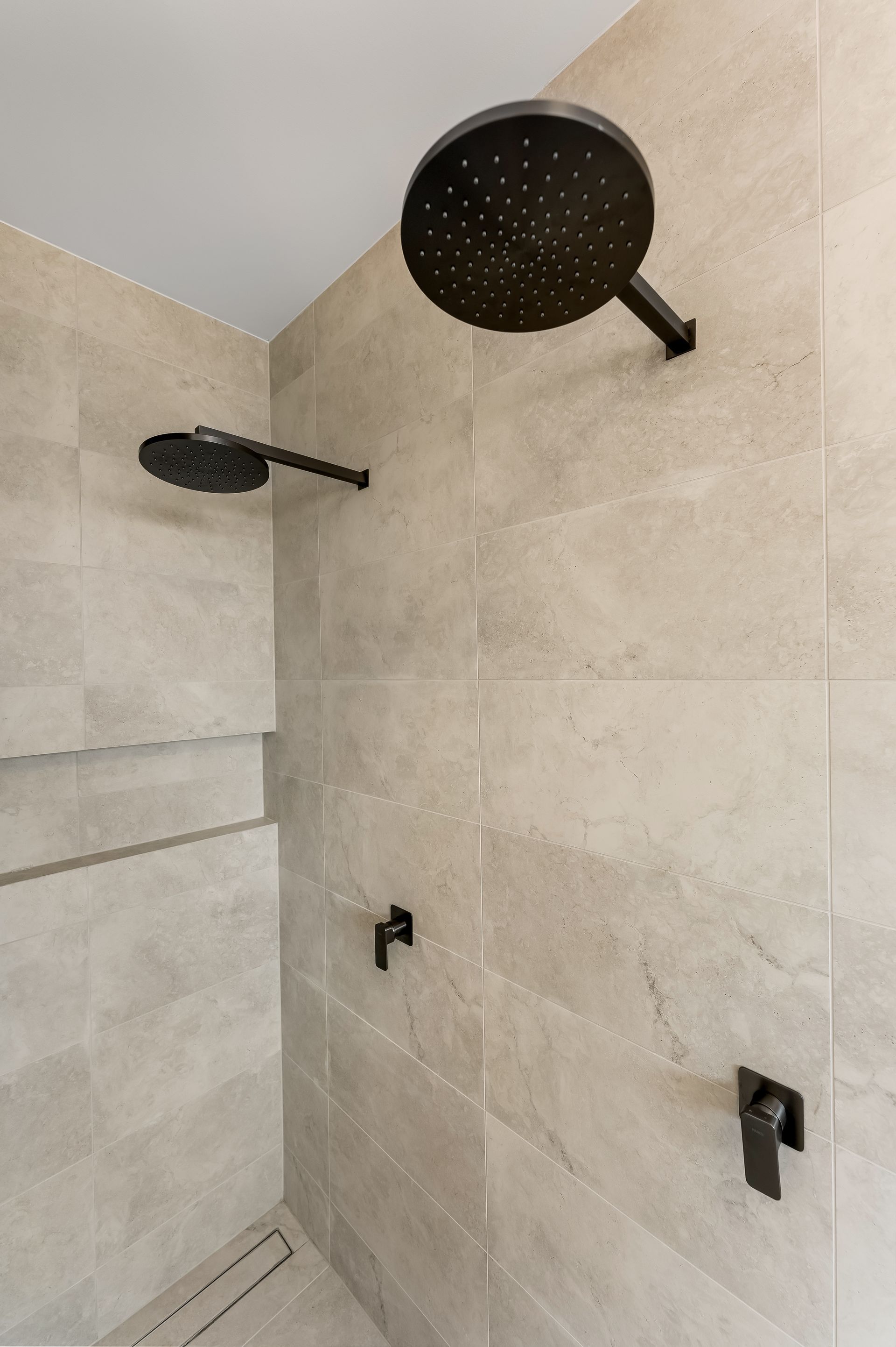 Modern Tiled Shower With Two Black Rain Showerheads and Wall Controls — Matt Made Building in Camden, NSW