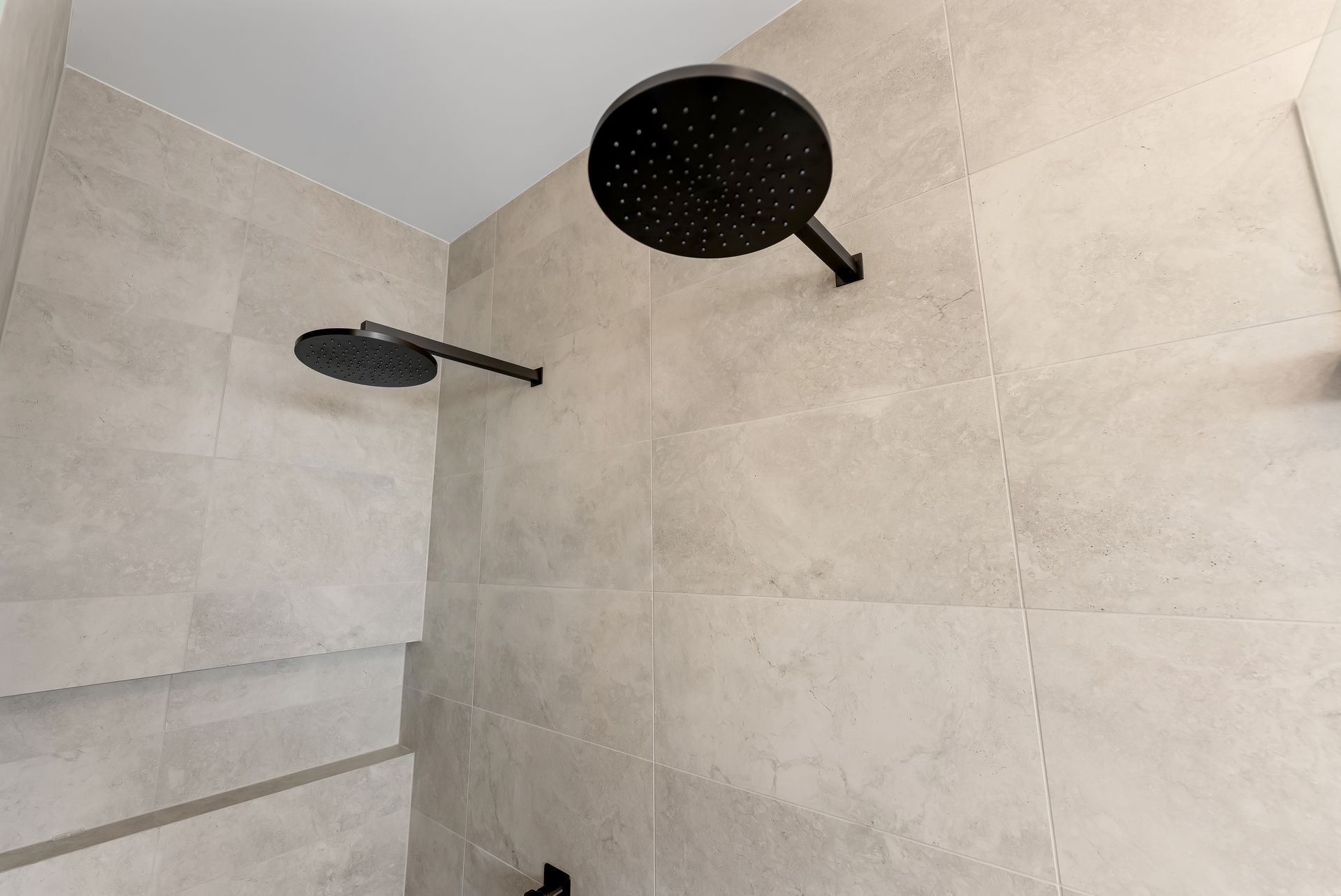 Bathroom Shower With Two Black Showerheads on Beige Tiled Walls — Matt Made Building in Camden, NSW
