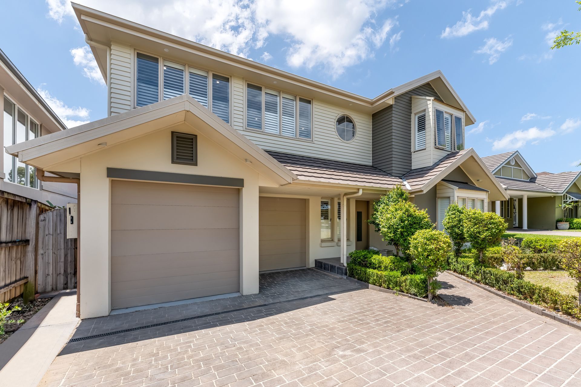 Modern Two-story House With Beige Siding and Paved Driveway Under a Blue Sky — Matt Made Building in Camden, NSW