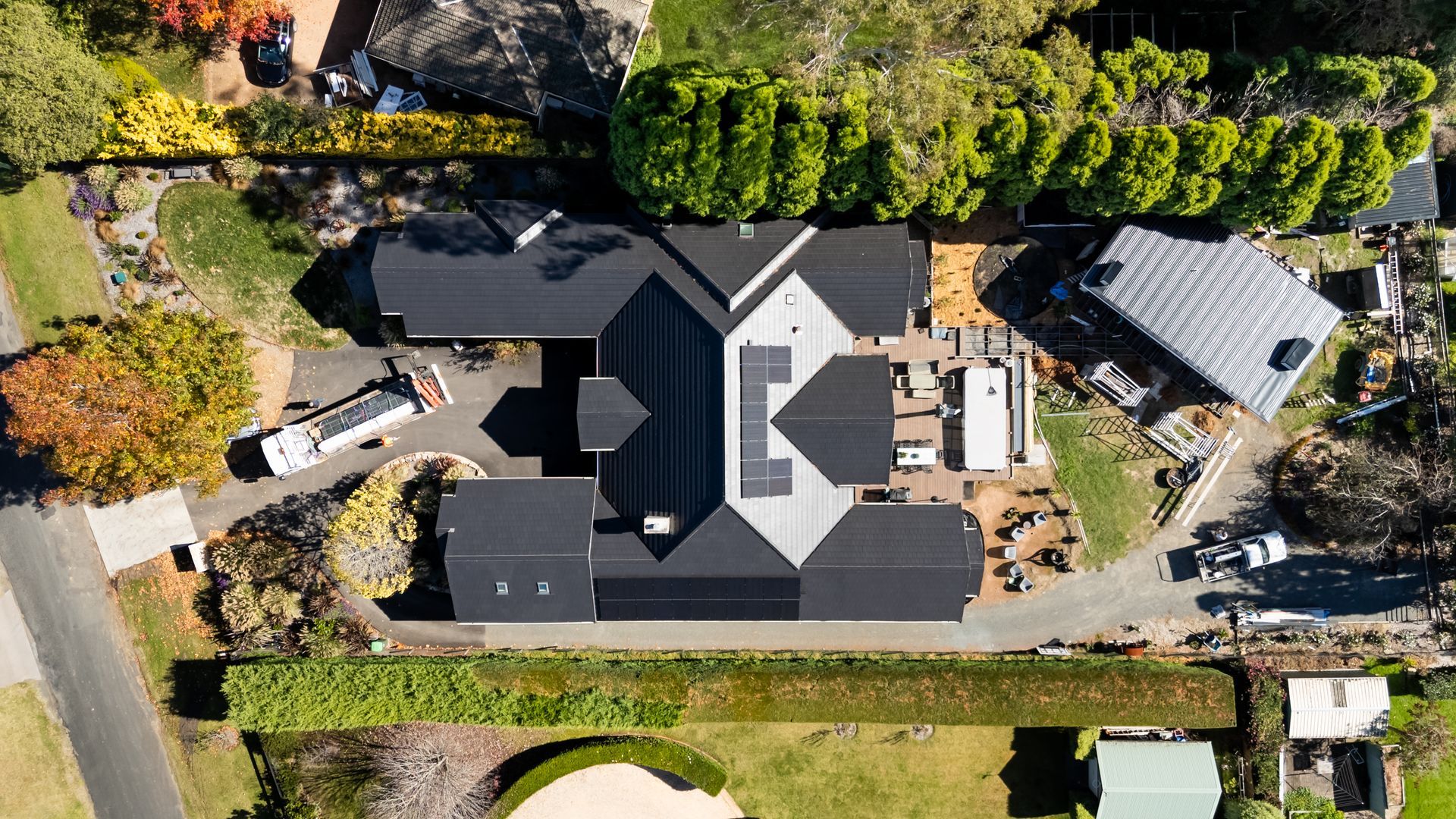 Aerial View of a Large Dark-roofed House With Driveway and Surrounding Trees — Matt Made Building in Camden, NSW