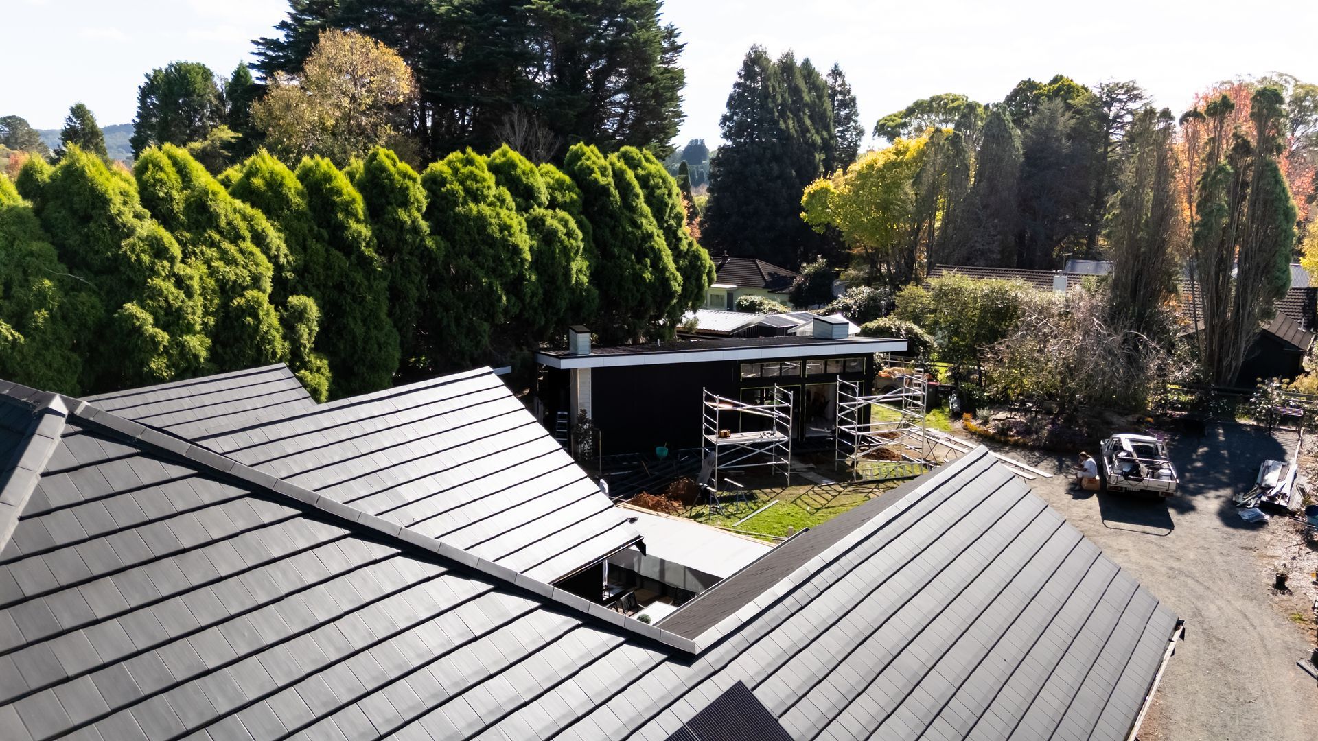 Residential Rooftops Overlooking a Tree-lined Driveway and Hillside Homes — Matt Made Building in Camden, NSW