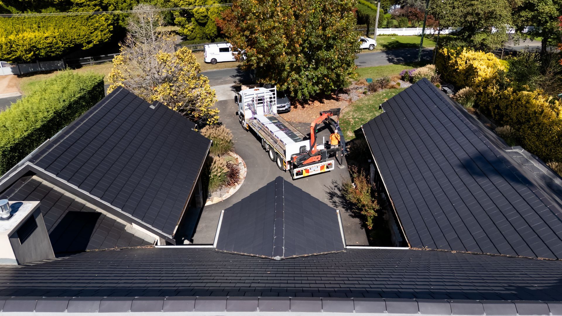 Aerial View of a Driveway Between Black-roofed Buildings With Two Workers — Matt Made Building in Camden, NSW