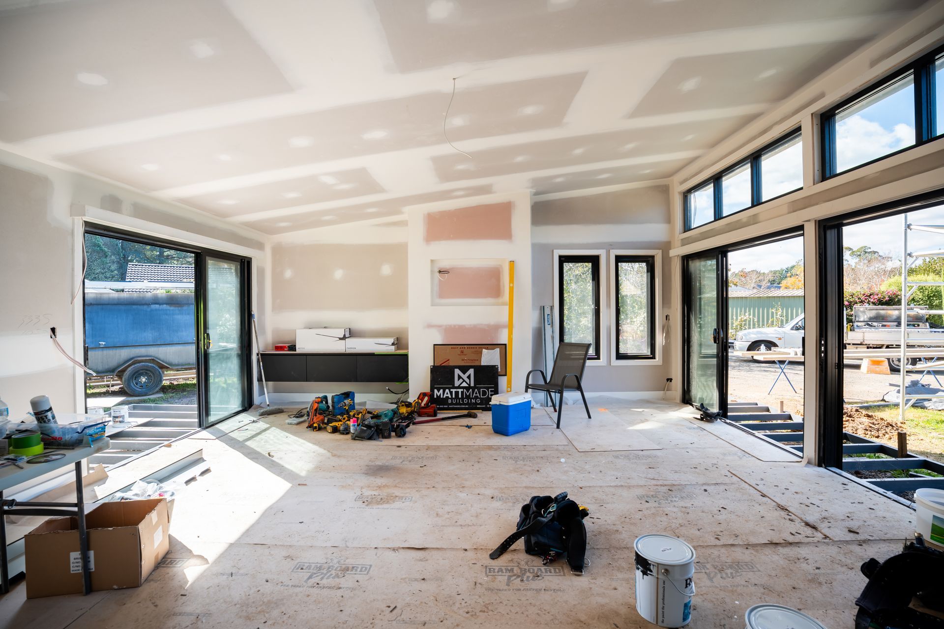 Bright Unfinished Room With Drywall and Open Glass Doors to a Sunny Outdoor View — Matt Made Building in Camden, NSW