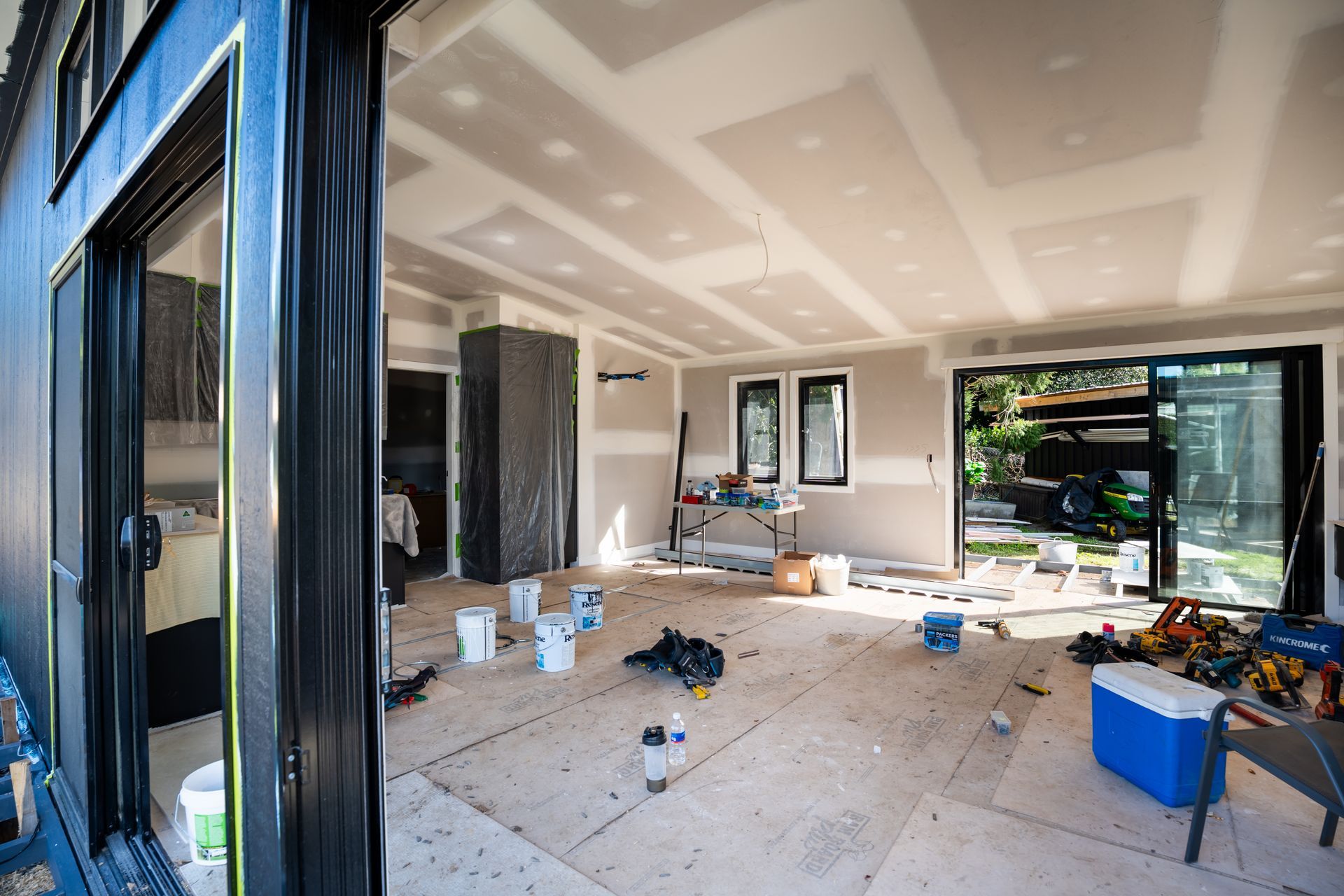 Renovated Living Room With Construction Tools and Open Glass Doors — Matt Made Building in Camden, NSW