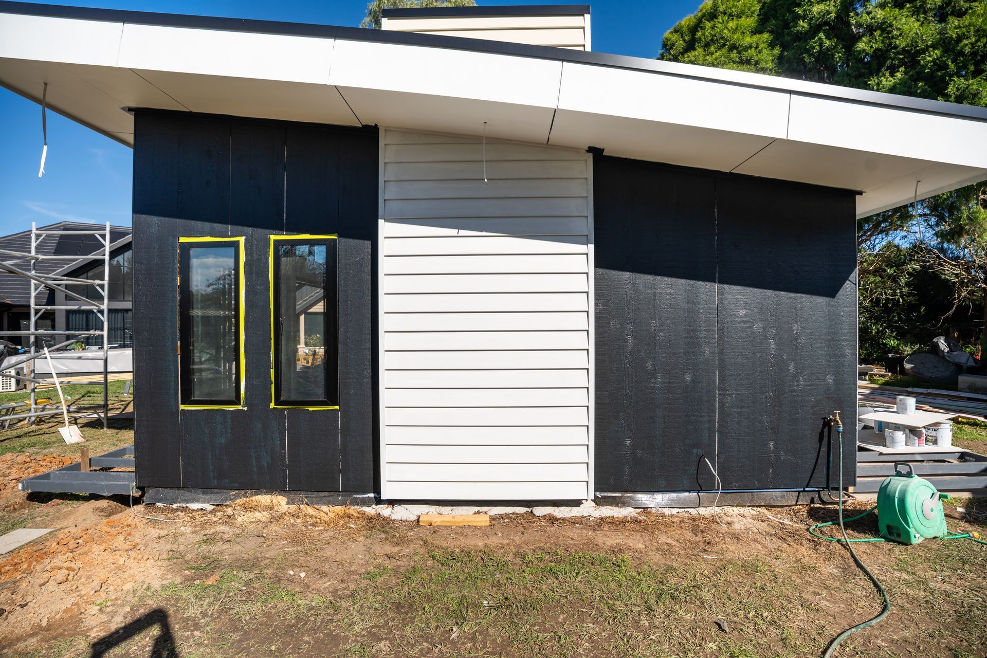 Small Modern House Exterior With White and Dark Panels and a Front Door With Windows — Matt Made Building in Camden, NSW