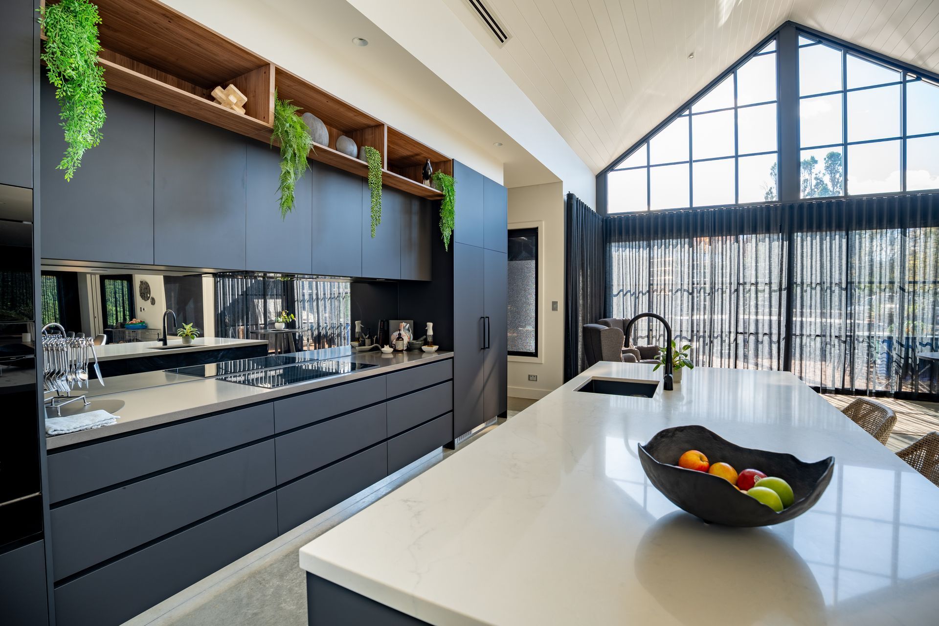 Modern Kitchen With Black Cabinetry and a Bowl of Fruit by Large Windows — Matt Made Building in Camden, NSW