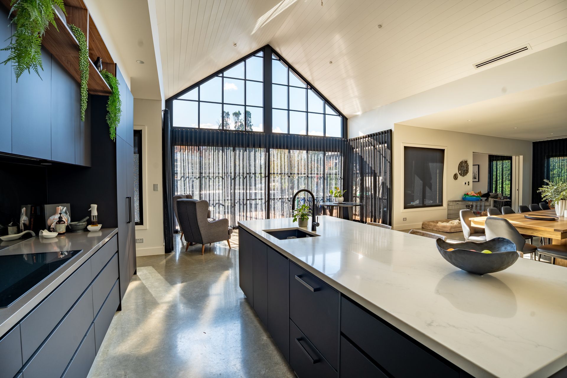 Modern Kitchen With a Large Island and a Tall Triangular Window Overlooking Trees — Matt Made Building in Camden, NSW