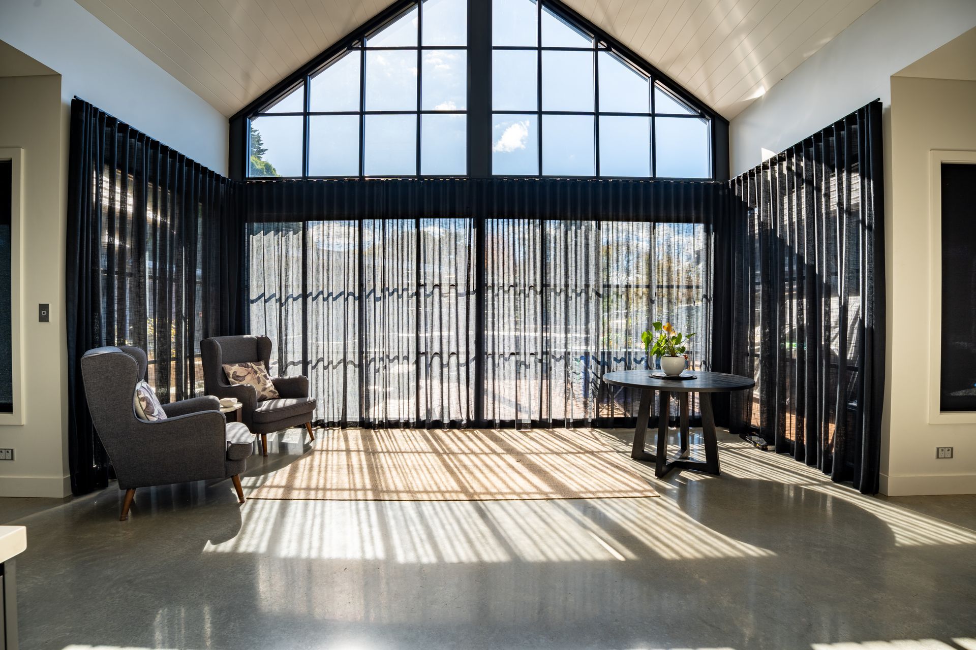Sunlit Modern Living Room With Tall Windows and Two Armchairs — Matt Made Building in Camden, NSW