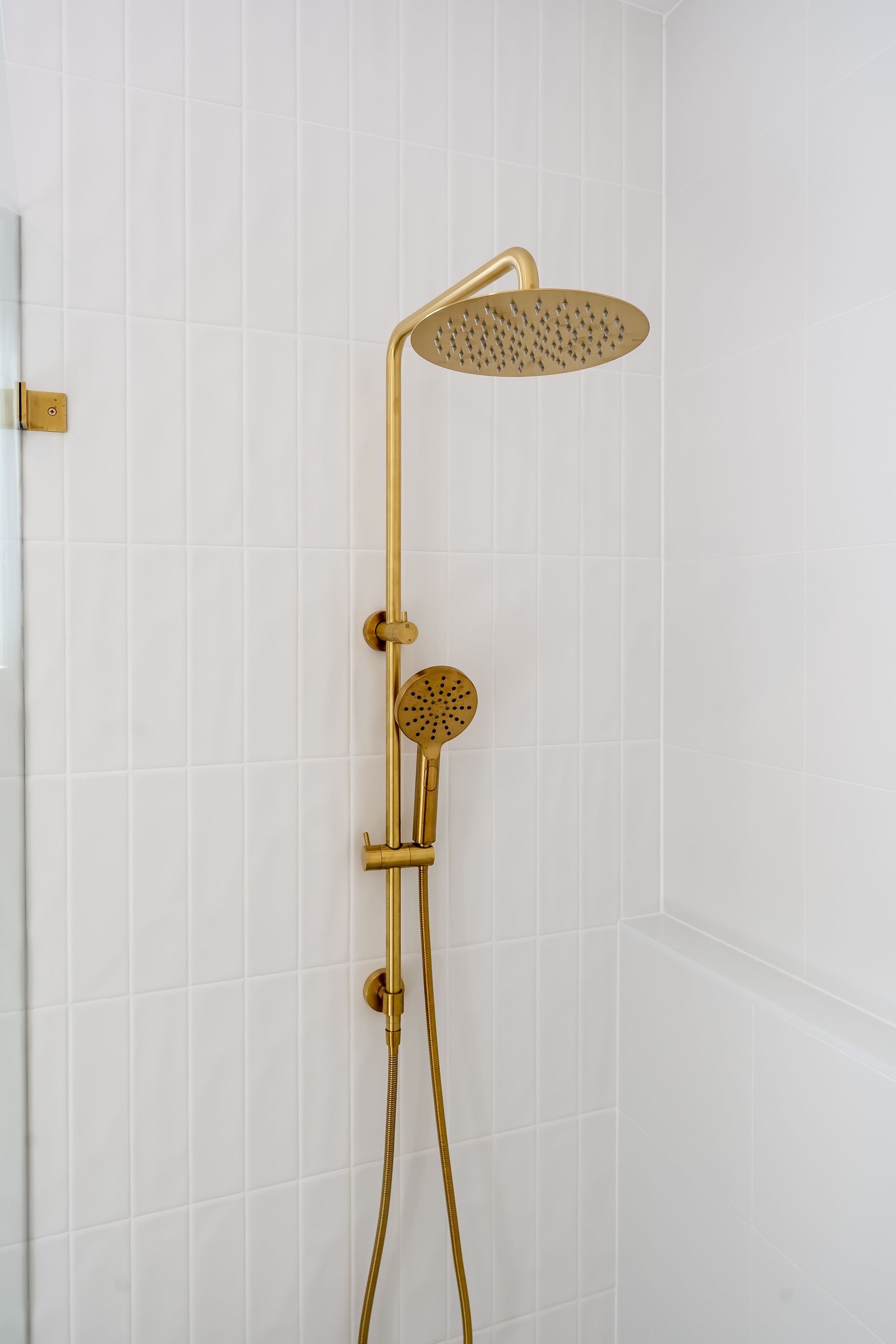 Gold Rainfall Showerhead and Handheld Shower in a White Tiled Shower — Matt Made Building in Camden, NSW