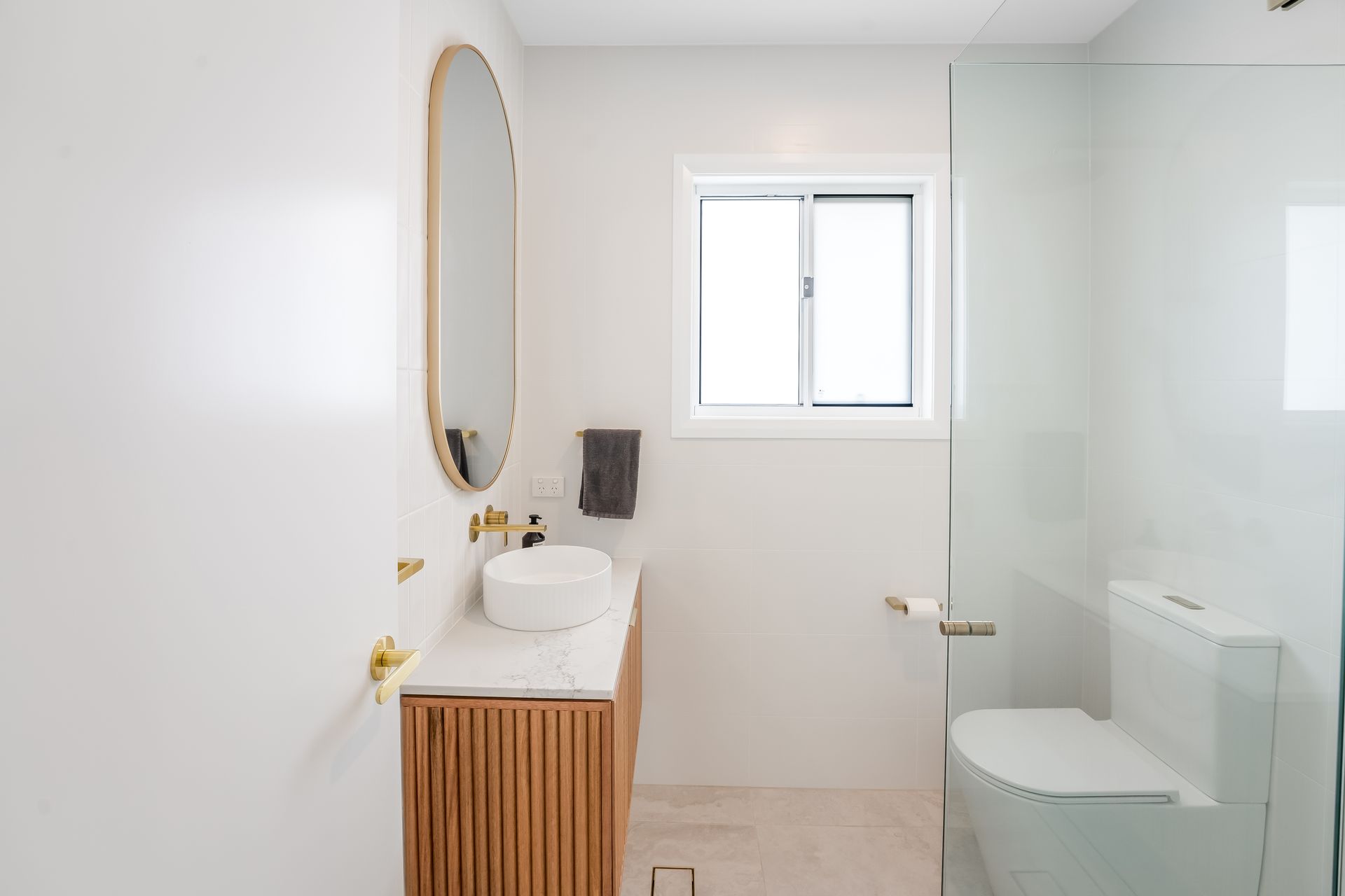 Modern White Bathroom With Wood Vanity and Glass Shower Door — Matt Made Building in Camden, NSW