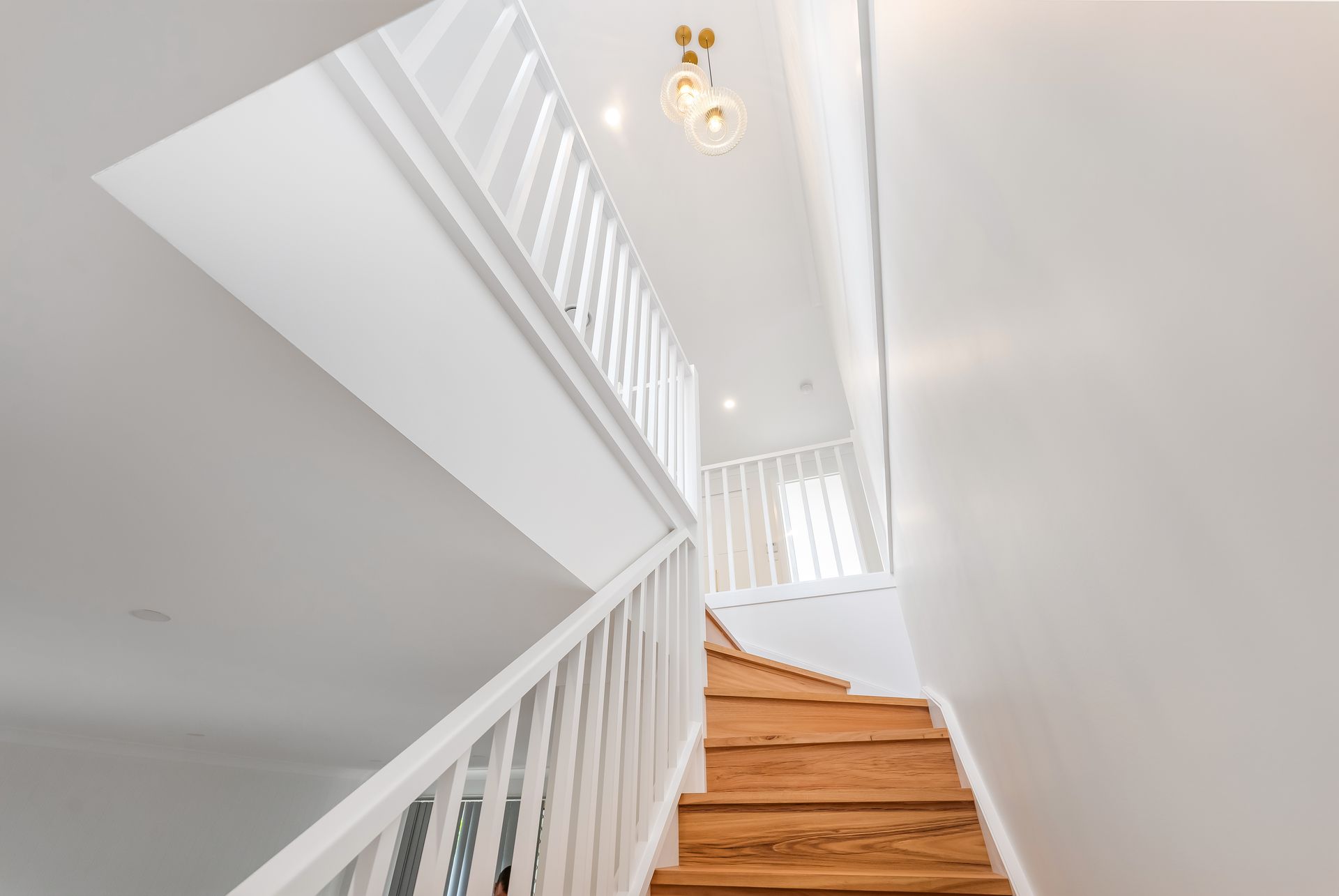 Bright White Staircase With Wooden Steps and a Hanging Light — Matt Made Building in Camden, NSW