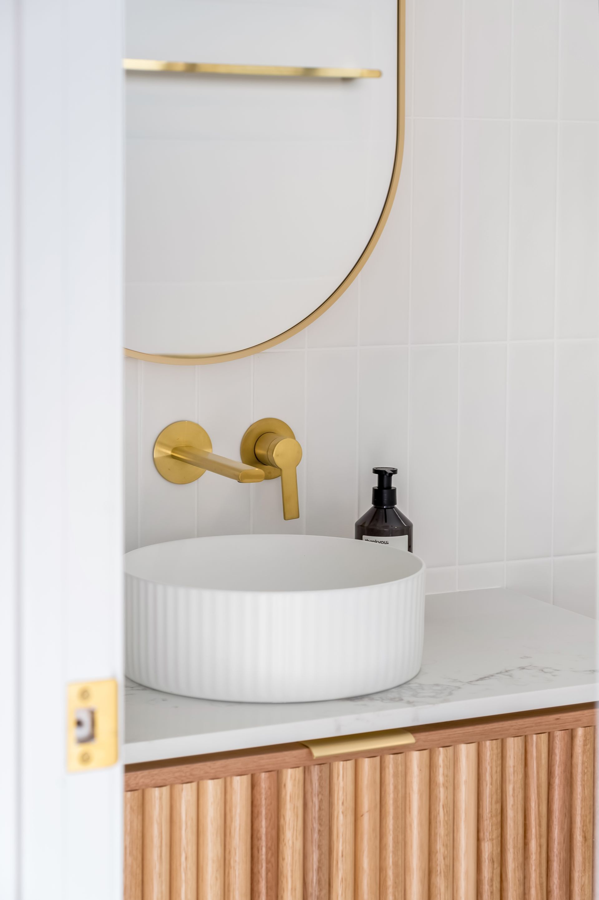 Minimal Bathroom Sink With Gold Faucet and Black Soap Dispenser — Matt Made Building in Camden, NSW