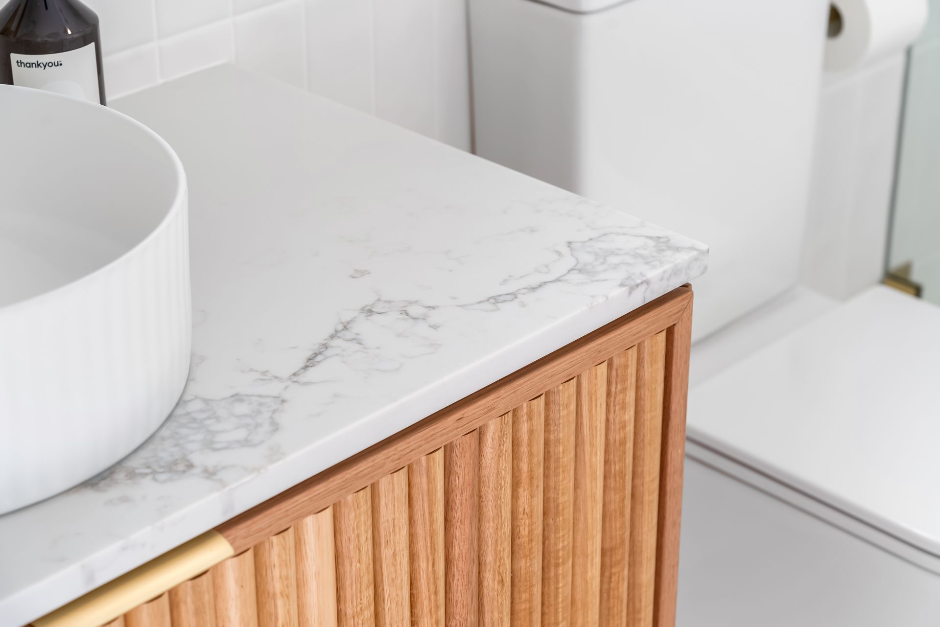 White Bathroom Vanity With Marble Countertop and Wood Slat Cabinet Front — Matt Made Building in Camden, NSW