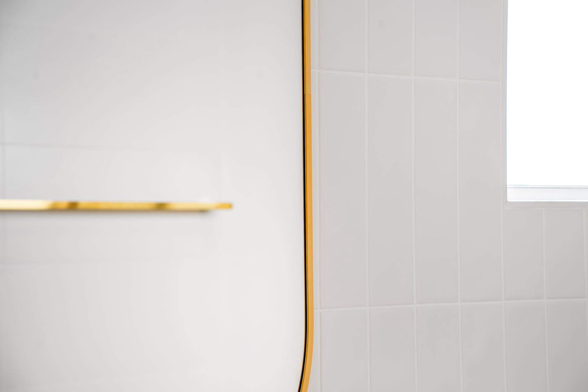 Close-up of a White Tiled Wall With a Vertical Gold-trimmed Seam — Matt Made Building in Camden, NSW