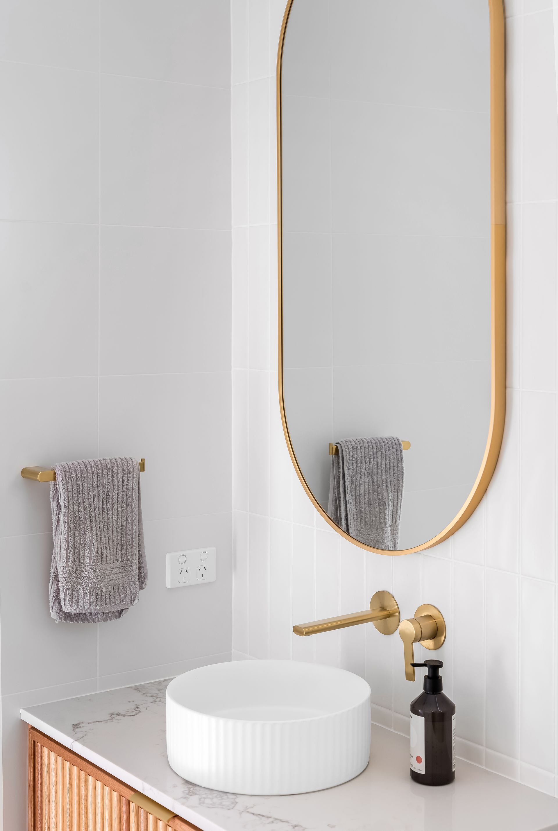 Modern Bathroom Vanity With Round Mirror and Gray Hand Towels — Matt Made Building in Camden, NSW