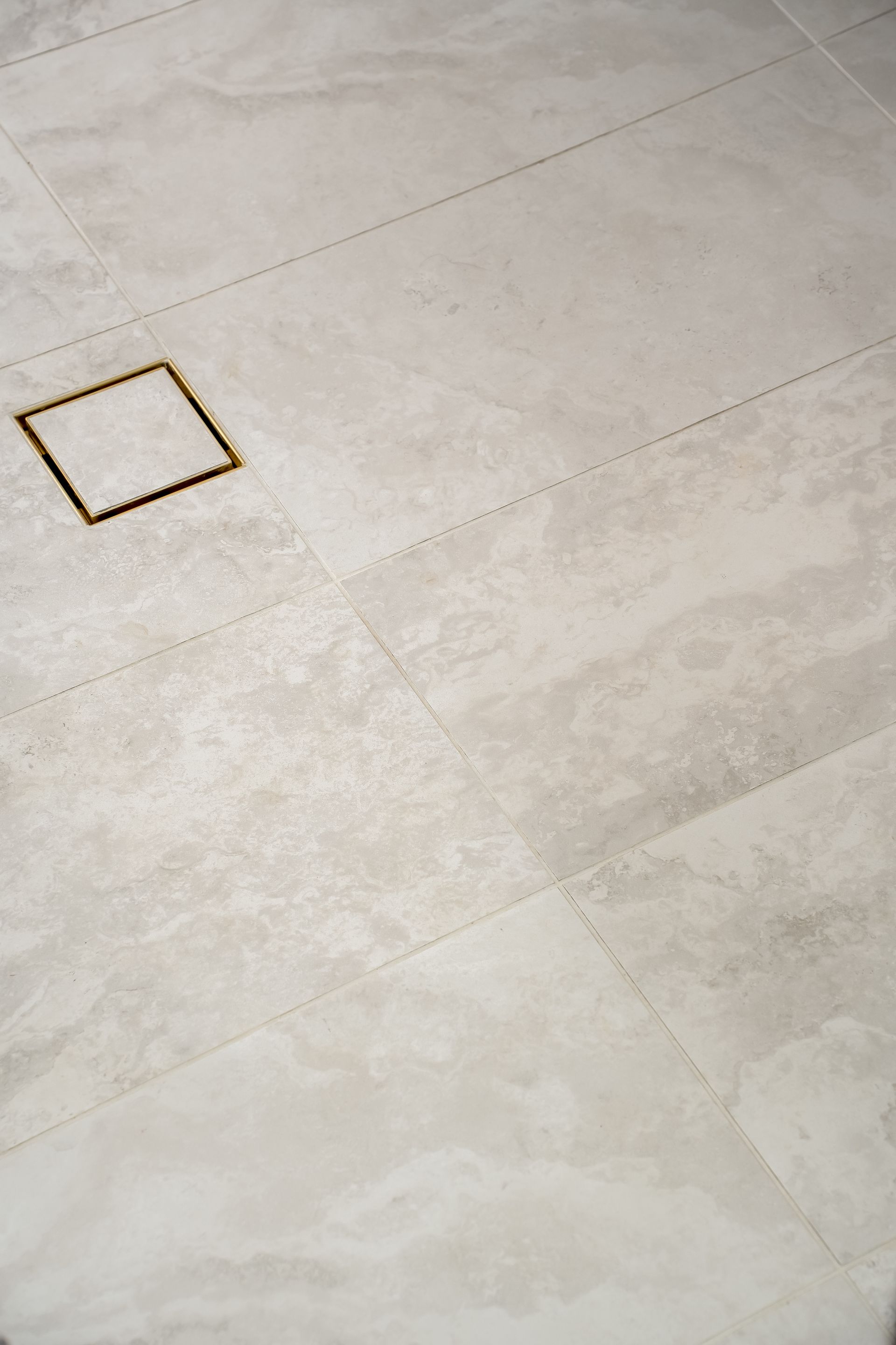 Light Beige Tiled Floor With a Small Square Floor Drain Near the Upper Left — Matt Made Building in Camden, NSW