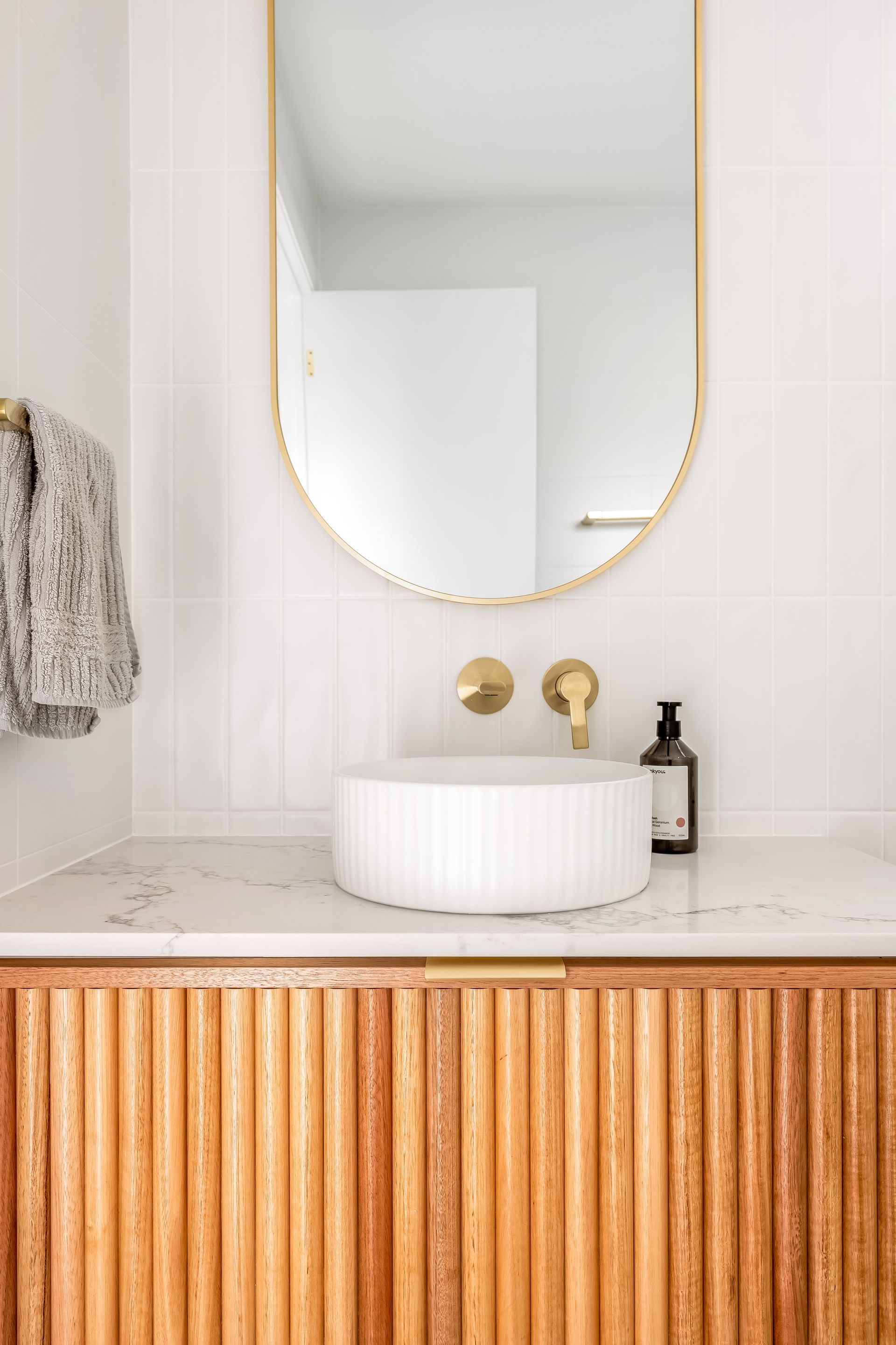 Modern Bathroom Vanity With Round Mirror and Wood-paneled Cabinet — Matt Made Building in Camden, NSW