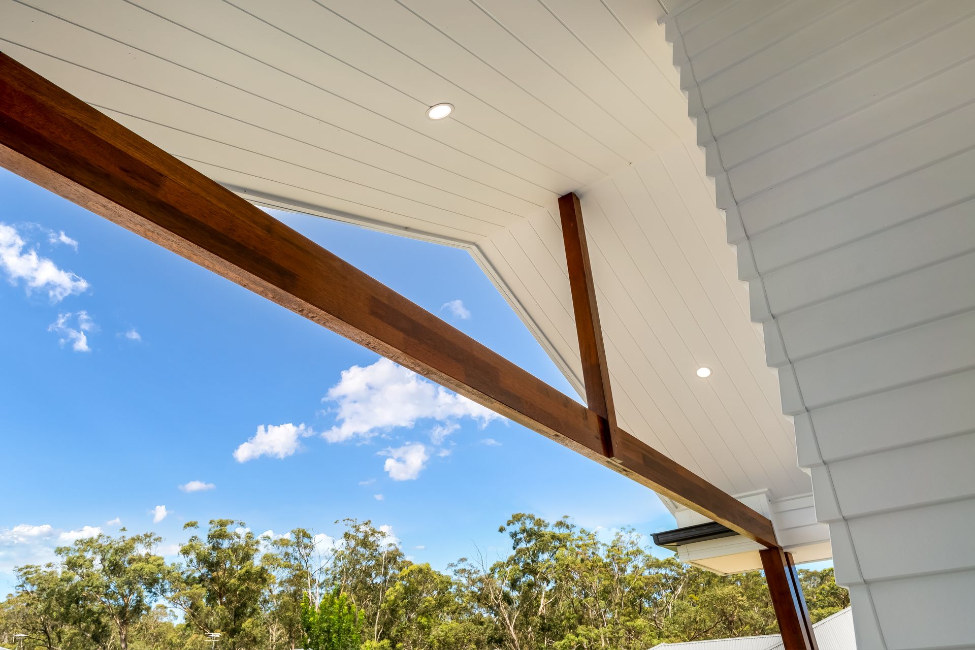Covered Outdoor Patio Ceiling With Wood Beams and Blue Sky Above Trees — Matt Made Building in Camden, NSW
