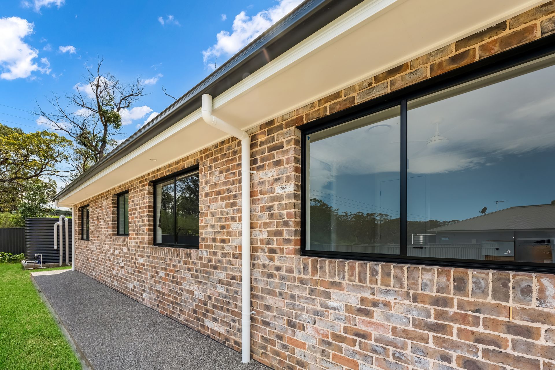 Brick House Exterior With Large Windows and a Gravel Side Yard — Matt Made Building in Camden, NSW