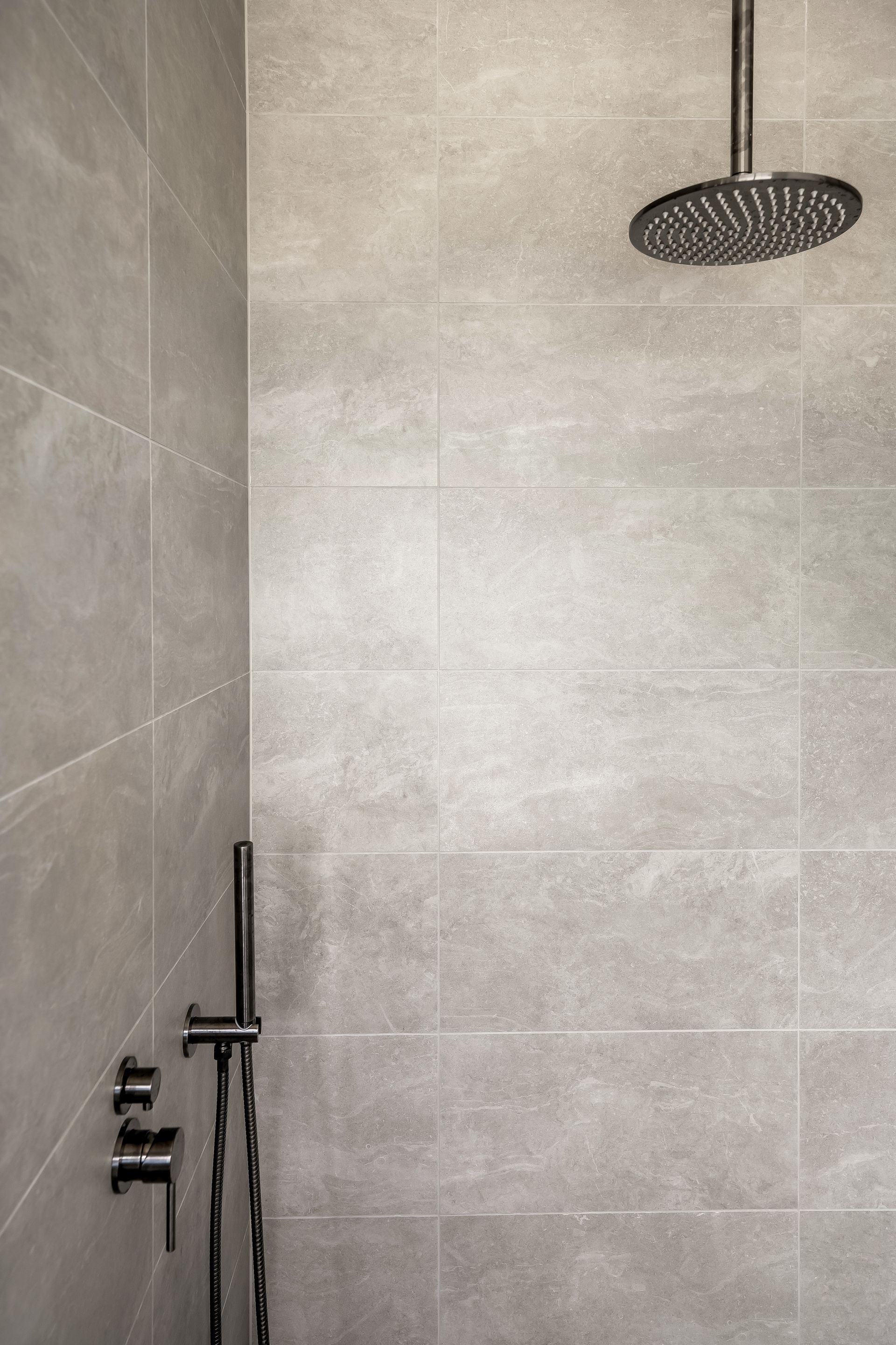 Modern Tiled Shower With a Rainfall Showerhead and Wall-mounted Controls — Matt Made Building in Camden, NSW