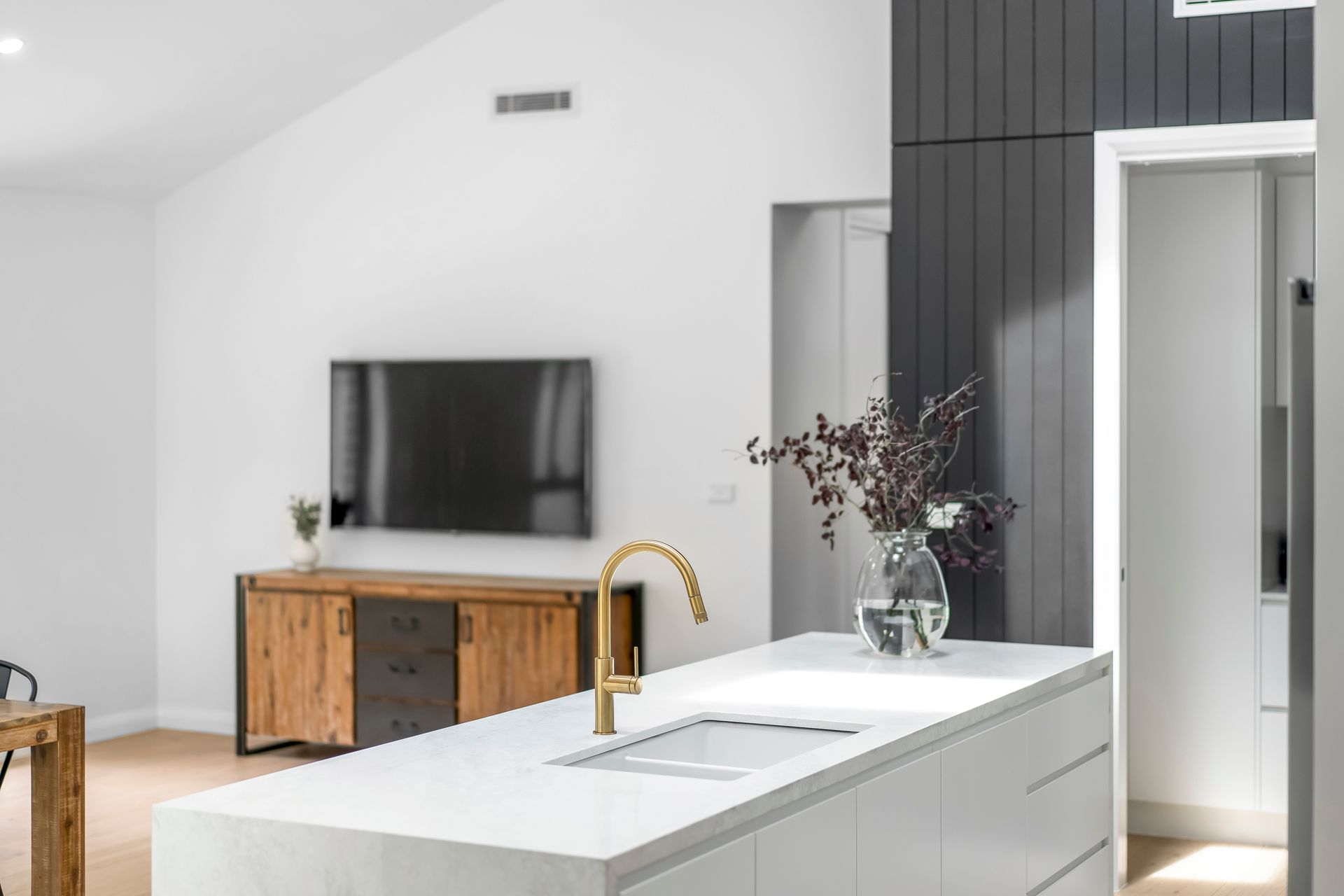 Modern Kitchen With White Island, Gold Faucet and Dark Gray Accent Wall — Matt Made Building in Camden, NSW
