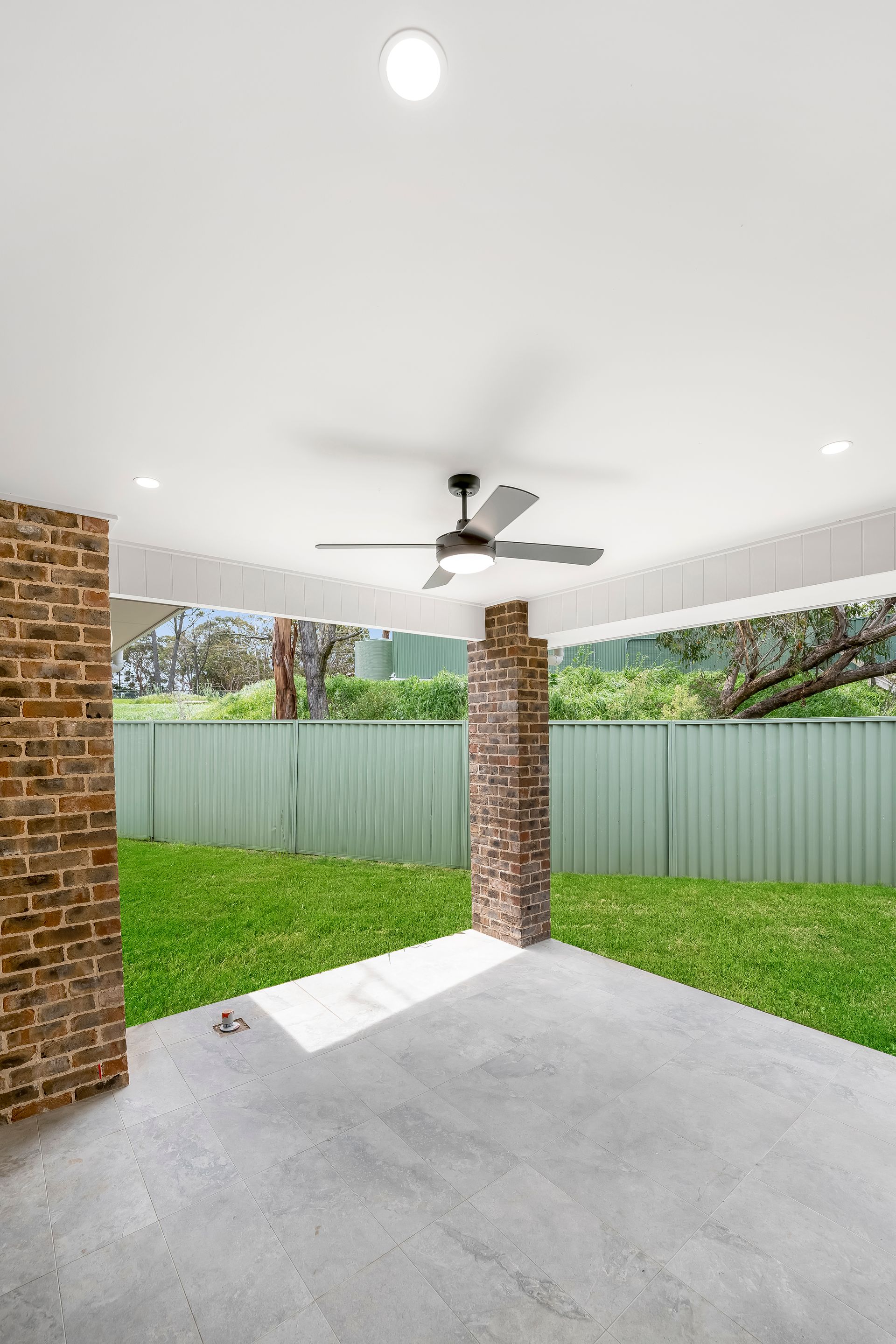 Covered Patio With Brick Columns, Ceiling Fan and Fenced Grassy Backyard — Matt Made Building in Camden, NSW