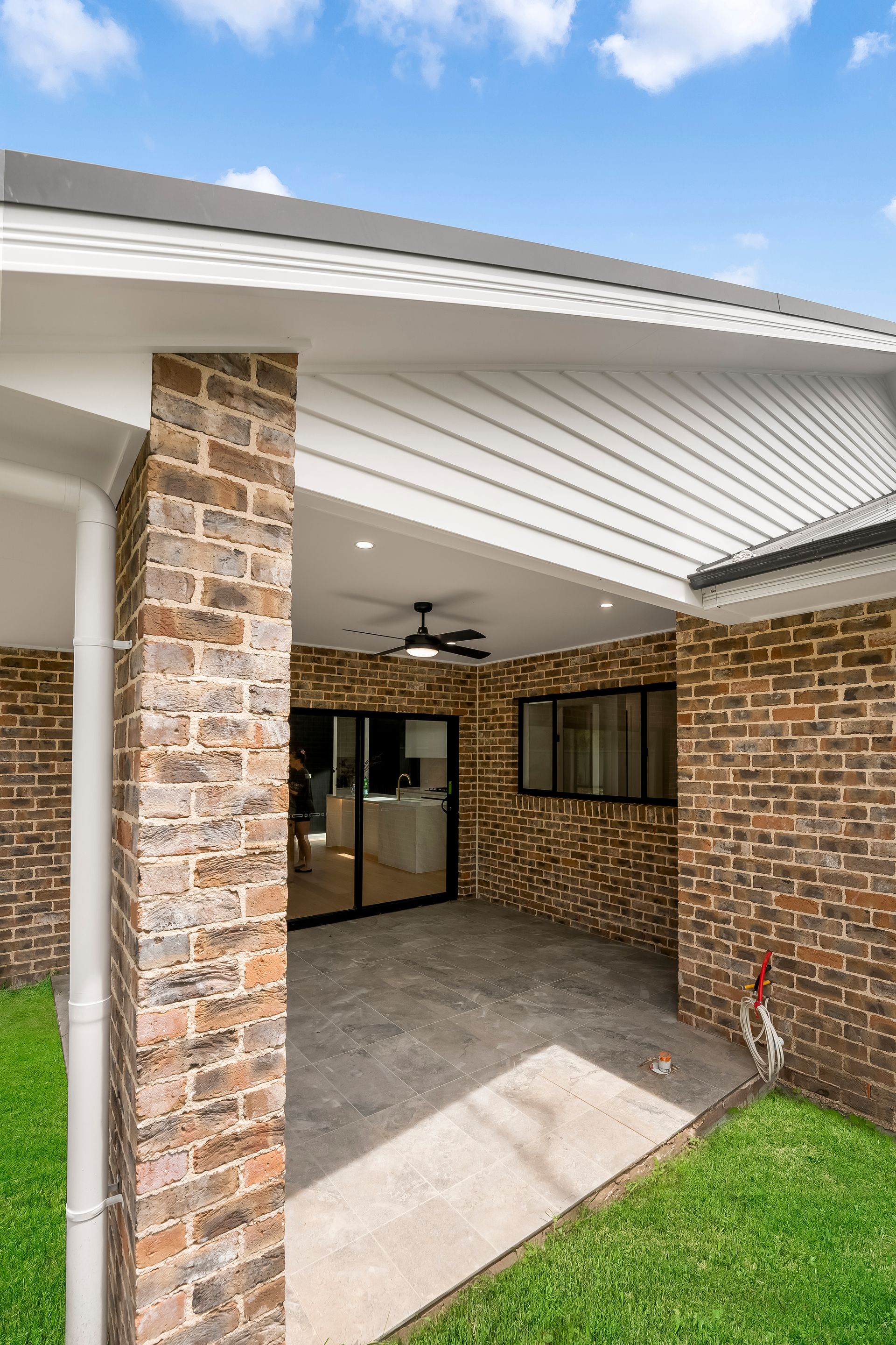 Covered Brick Patio With White Ceiling Fan and a Small Lawn — Matt Made Building in Camden, NSW