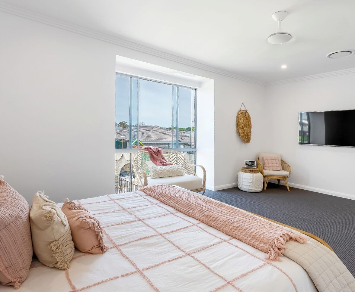 Bright Bedroom With a Bed, Window Seat, Wall-mounted TV — Matt Made Building in Wollongong, NSW