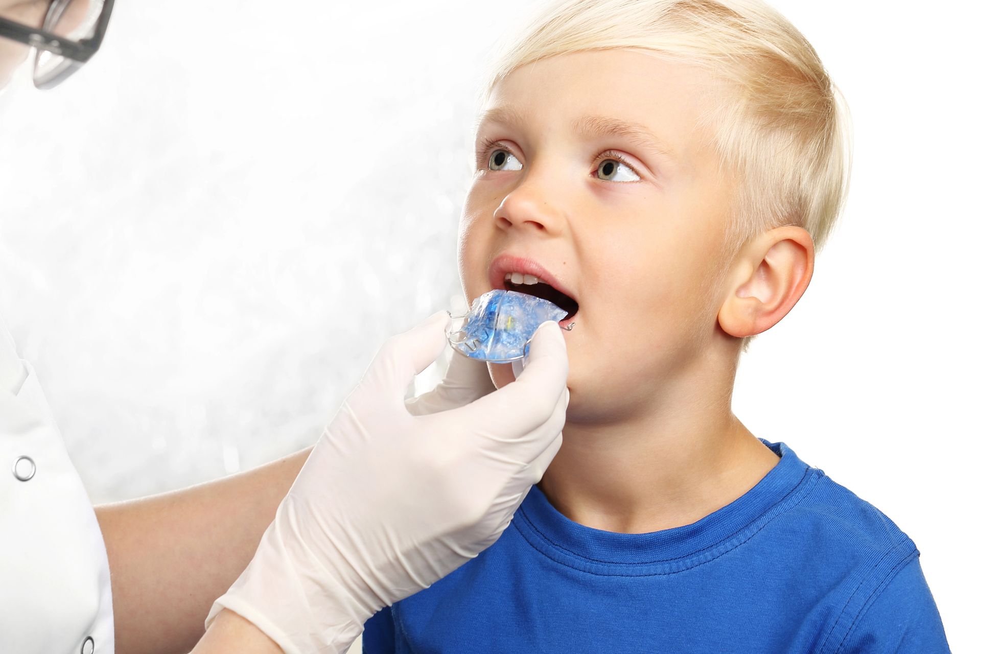 Un niño recibe una muestra oral de un trabajador sanitario con guantes.