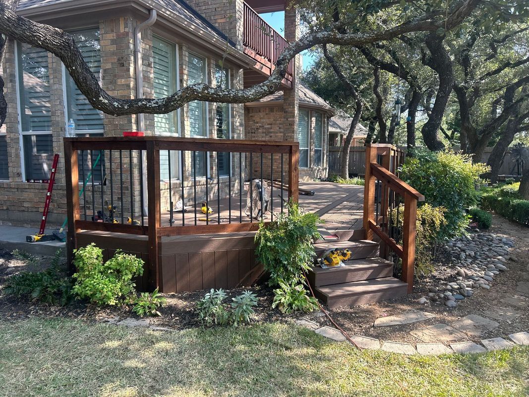 Wooden backyard chicken coop with stairs, surrounded by trees and garden plants