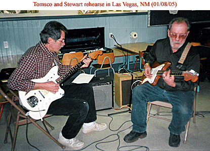 two men holding guitars sitting down