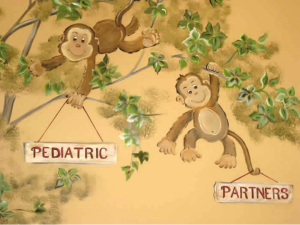 Cartoon monkeys on tree branches holding signs reading “PEDIATRIC” and “PARTNERS”