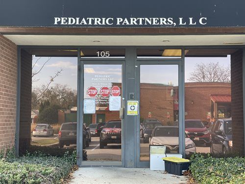 Front entrance of Pediatric Partners, LLC with glass doors and brick facade.