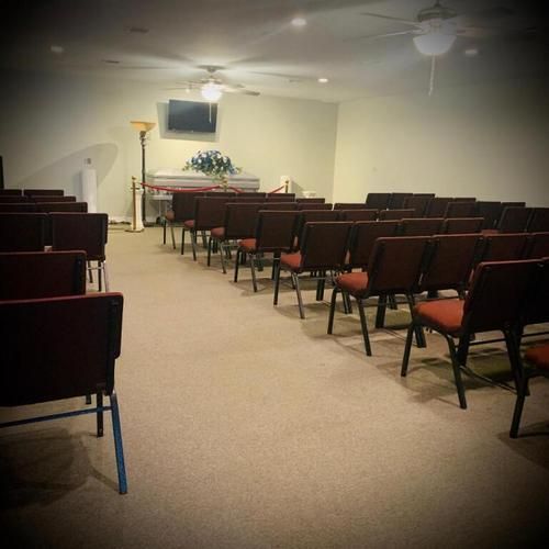 Empty church sanctuary with rows of red chairs facing a pulpit and cross