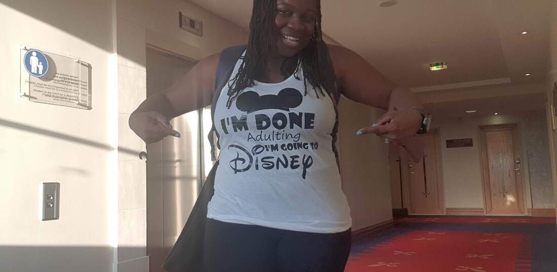 Person standing in a hallway wearing a white shirt that says “I’M DONE WITH DISNEY”