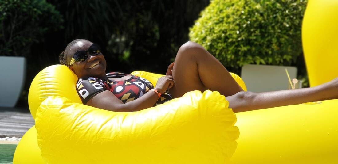 Person relaxing on a bright yellow inflatable float outdoors in the sun