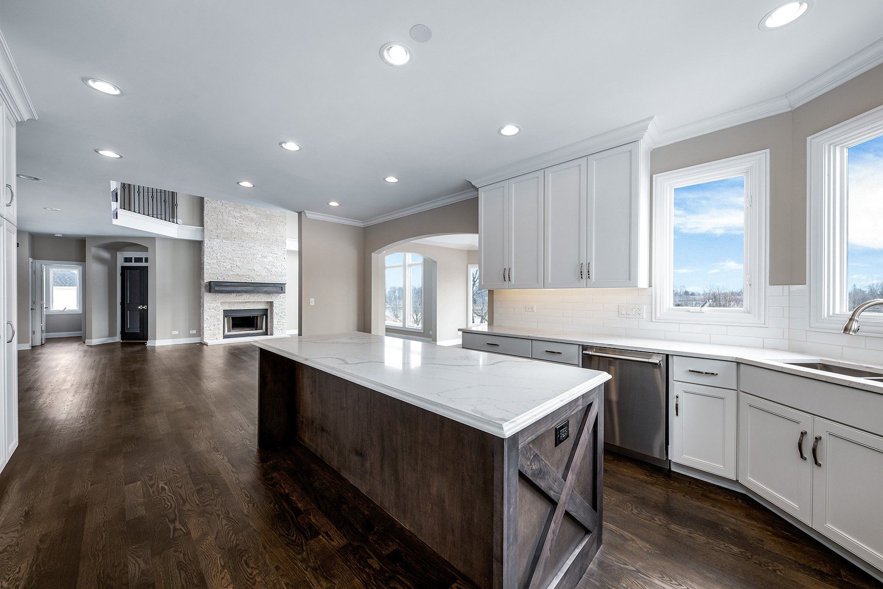 An empty kitchen with a large island in the middle of it.