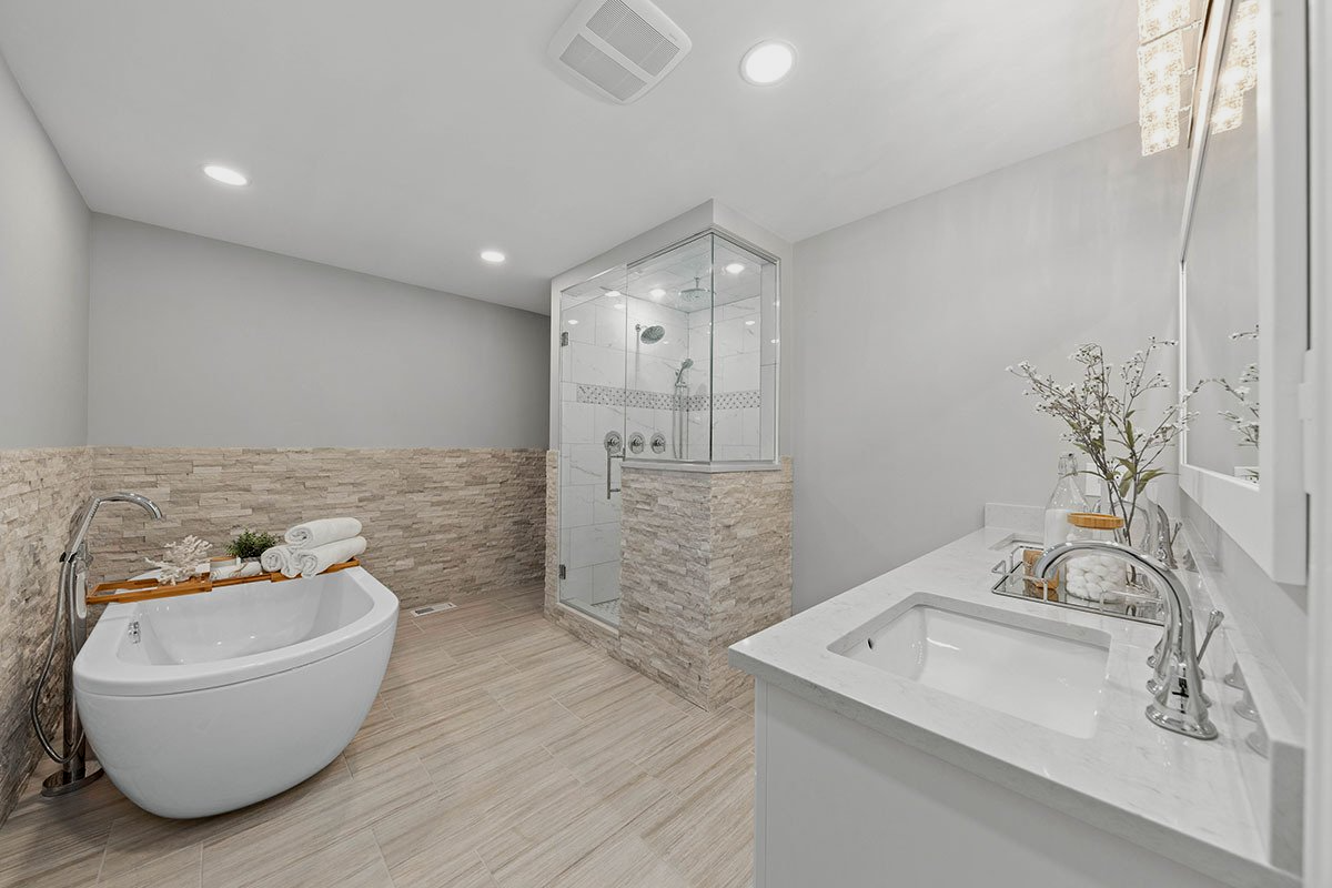 A bathroom with a bathtub , sink , and shower.