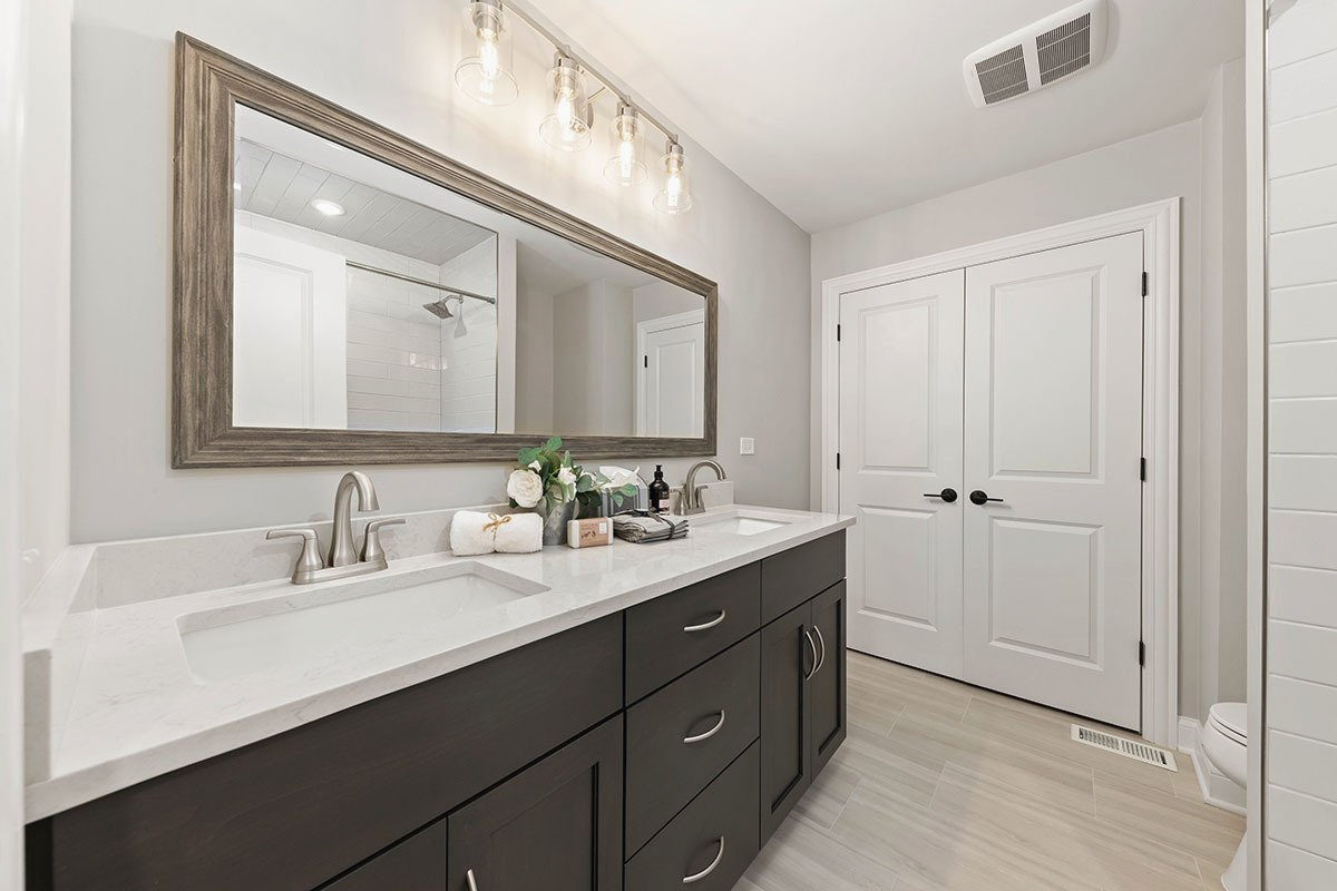 A bathroom with two sinks and a large mirror.