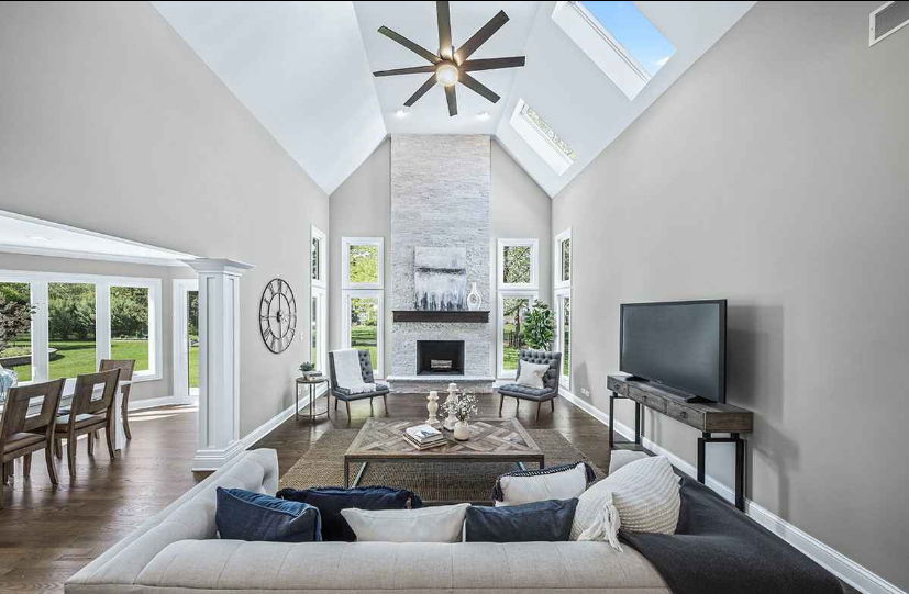 A living room with a ceiling fan and a fireplace